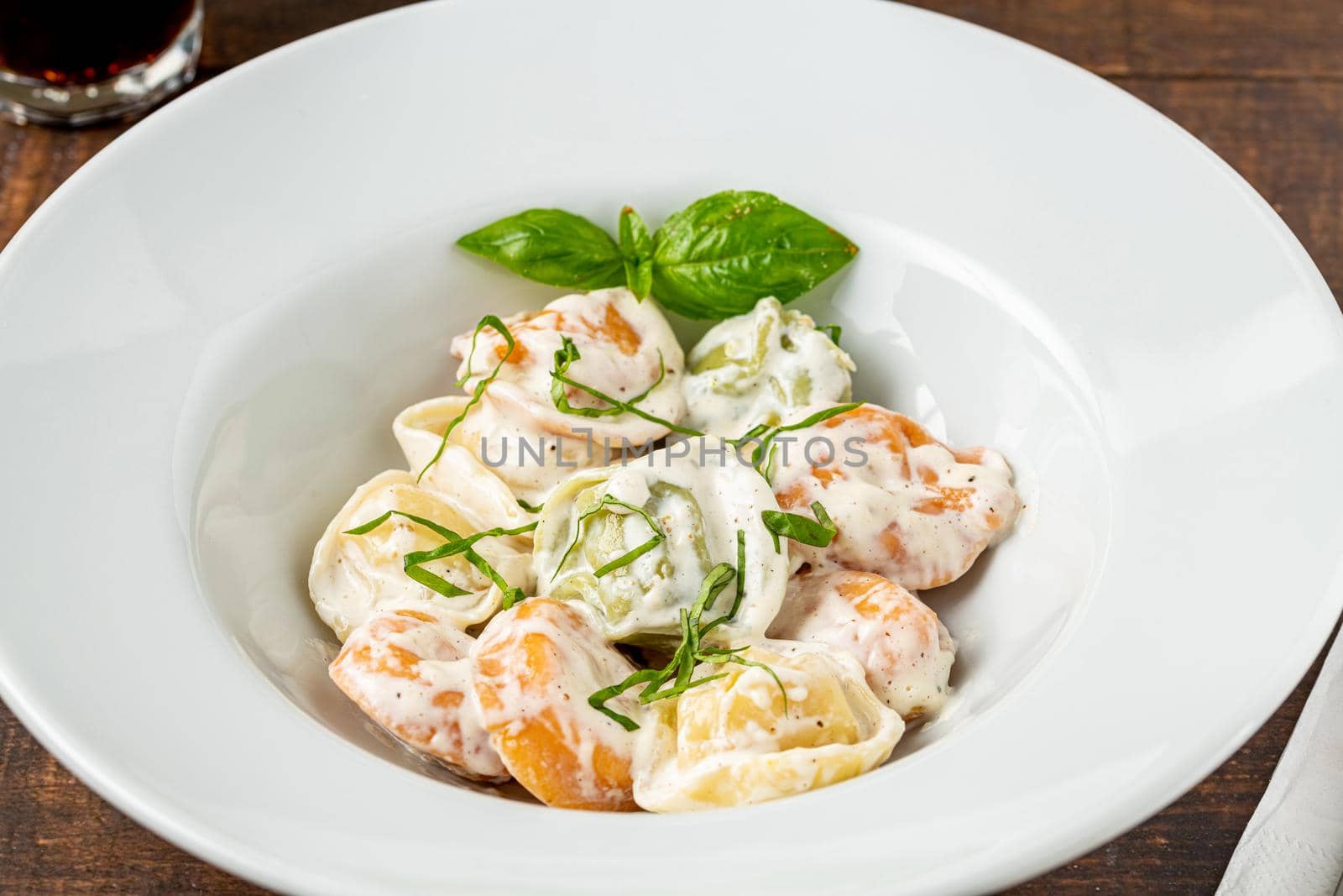 different types of pelmeni or russian dumplings in white plate on wooden background by Sonat