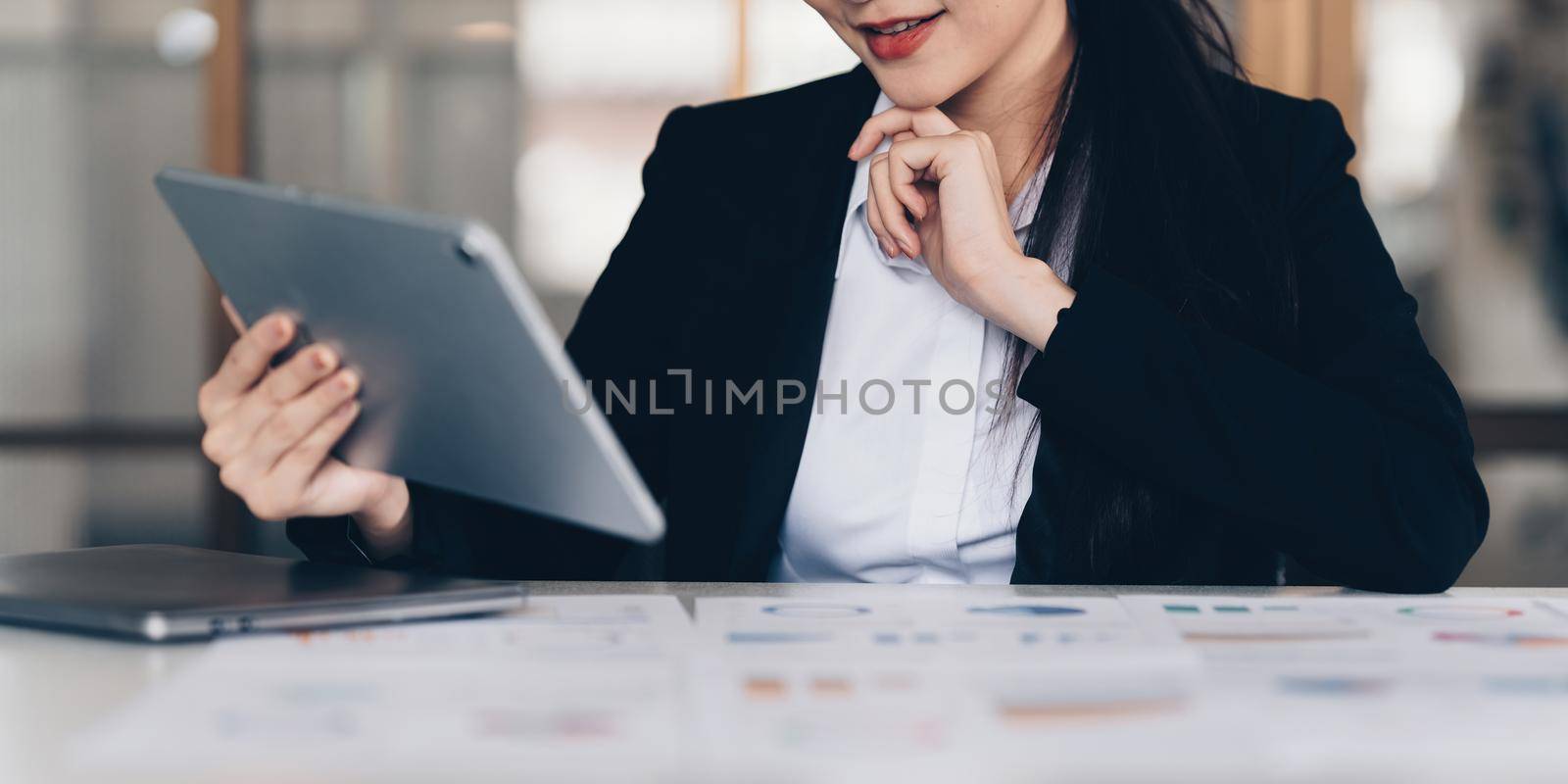 Asian Business woman working to analyze technical price graph and indicator with business team talking by cell phone. account or saving money or insurance concept.