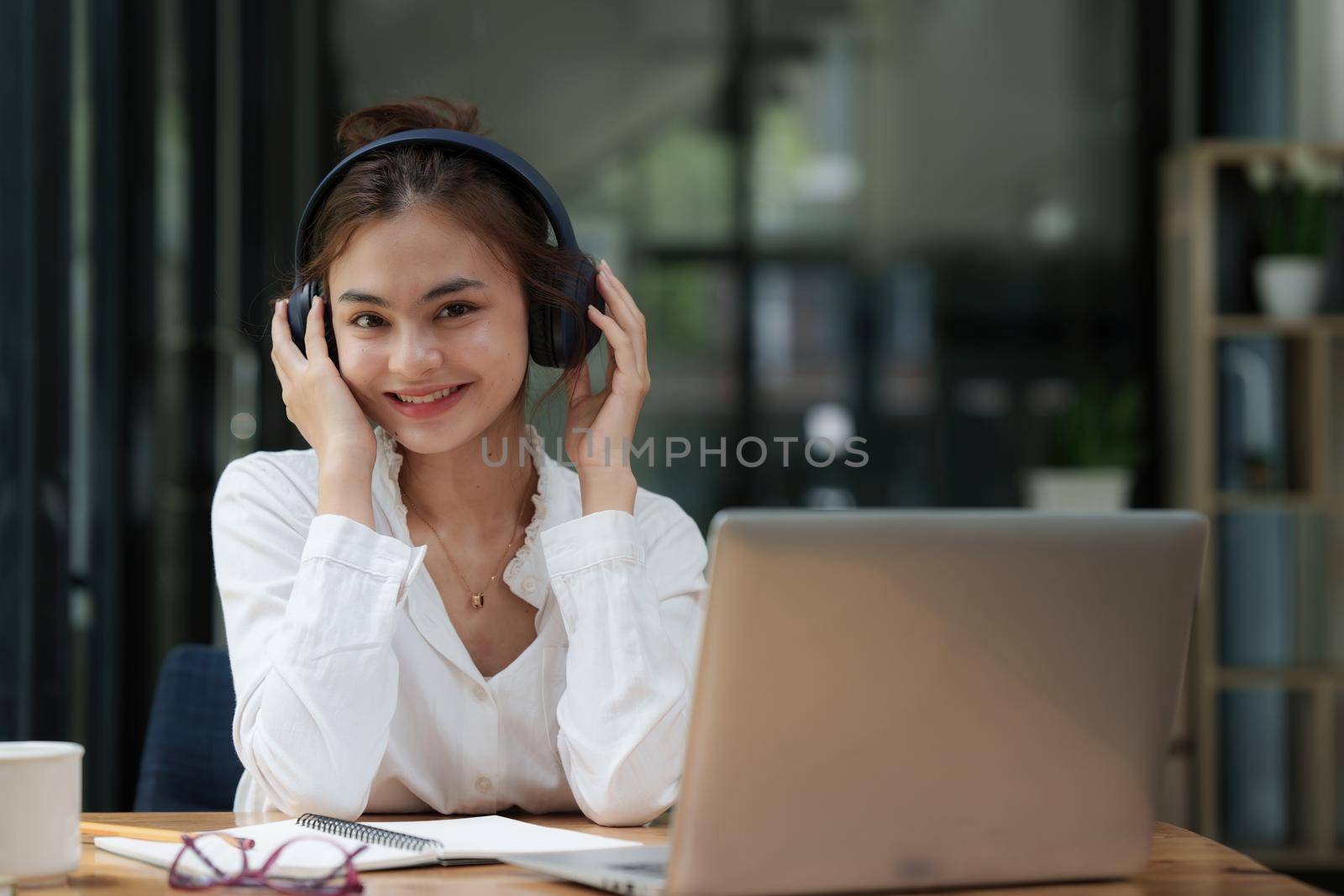 Attractive smiling young woman using mobile phone and listen music at home. lifestyle concept by itchaznong