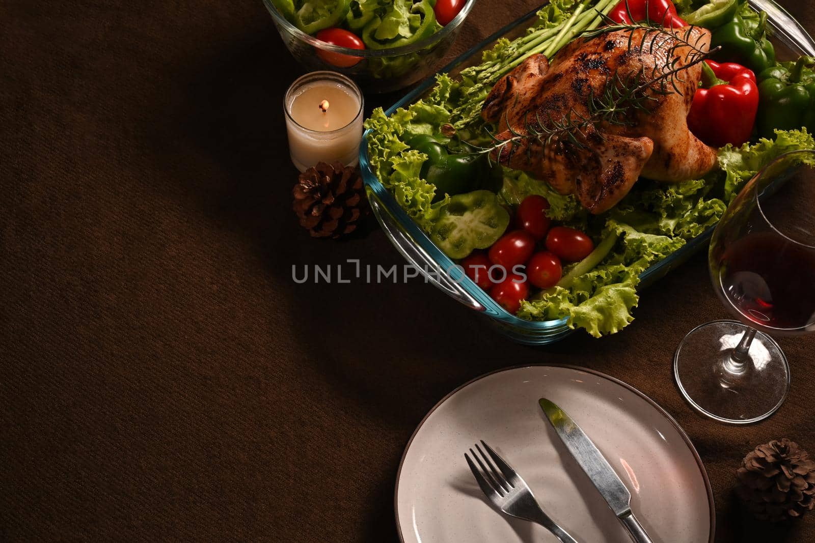 Above view of winter holiday table served, decorated with candles, roast turkey red wine on brown background by prathanchorruangsak