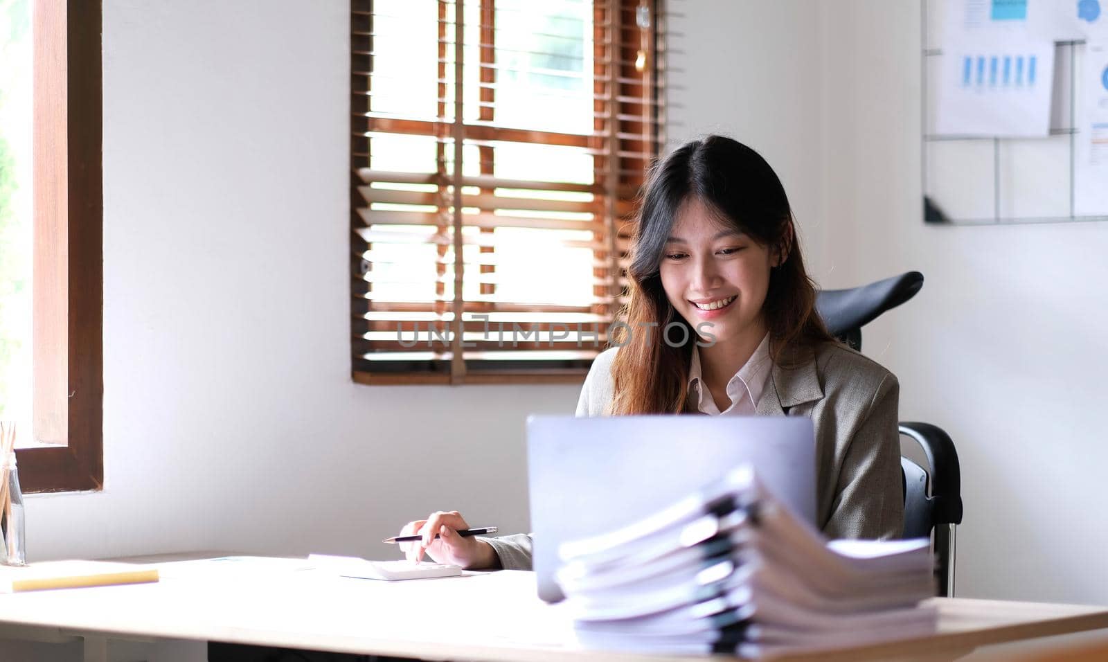 Portrait of smiling beautiful business asian woman working in office use computer with copy space. by wichayada