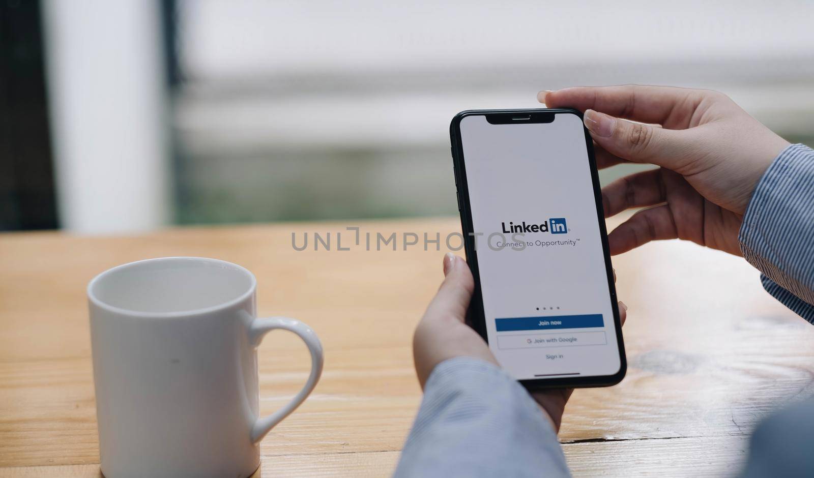 CHIANG MAI, THAILAND, JUL 27, 2022 : A women holds Apple iPhone Xs with LinkedIn application on the screen.LinkedIn is a photo-sharing app for smartphones..