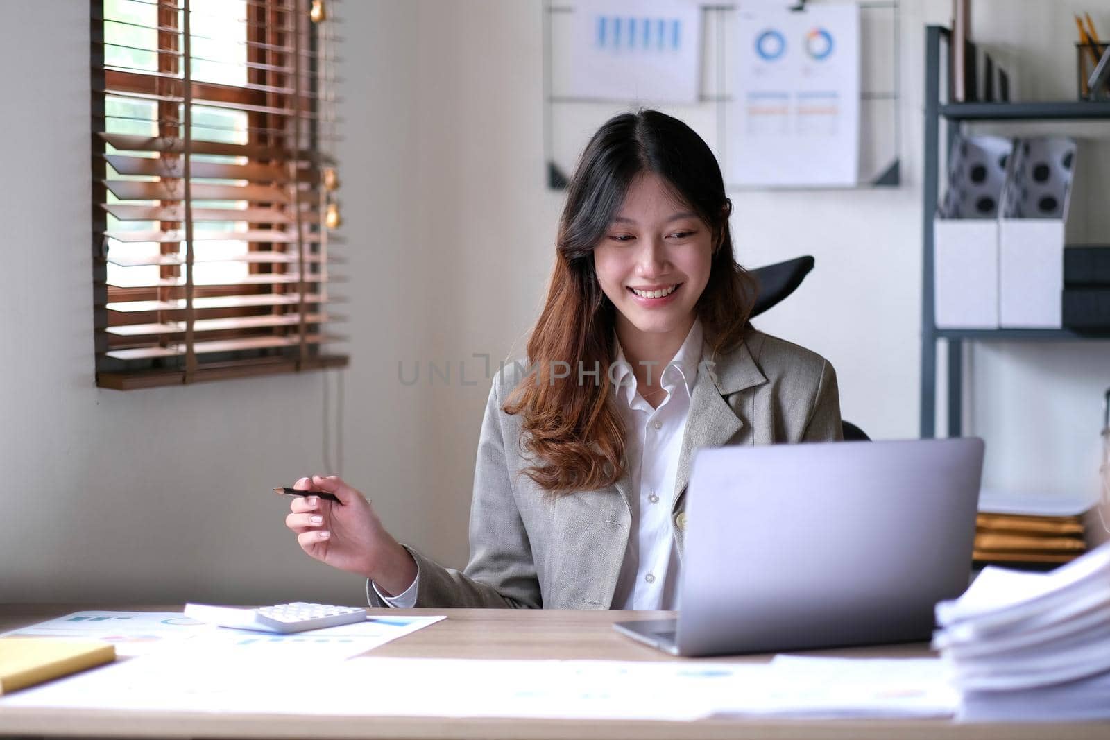 Portrait of smiling beautiful business asian woman working in office use computer with copy space