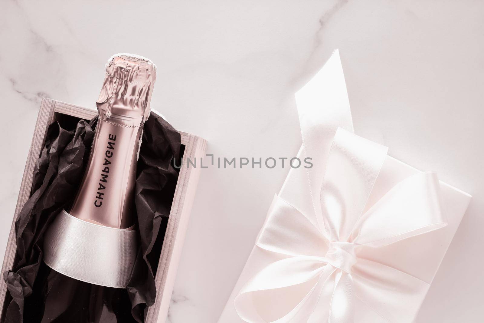Celebration, drink and branding concept - Champagne bottle and gift box on marble, New Years, Christmas, Valentines Day or wedding holiday present and luxury product packaging for beverage brand