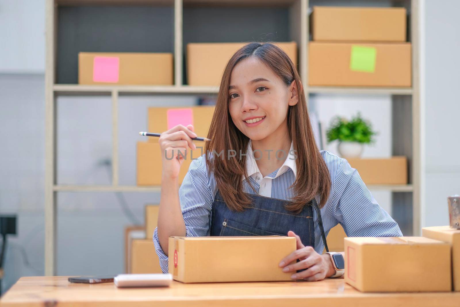 Portrait of Starting small businesses SME owners female entrepreneurs working on receipt box and check online orders to prepare to pack the boxes, sell to customers, sme business ideas online..