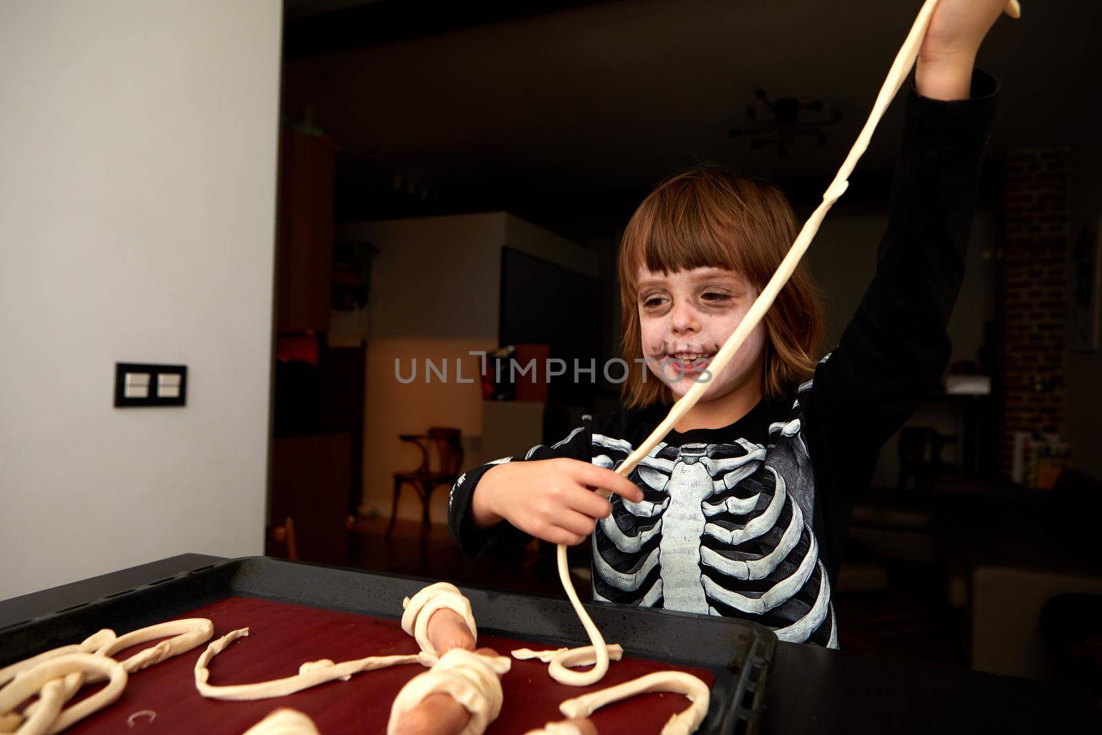 Boy child in skeleton costume preparing for halloween holiday by Demkat