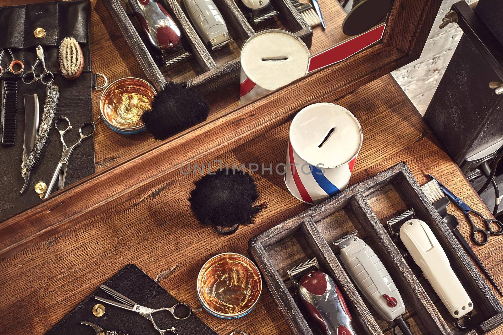 Hairdresser tools on wooden background. Top view on wooden table with scissors, comb, hairbrushes and hairclips, trimmer. Barbershop, manhood concept