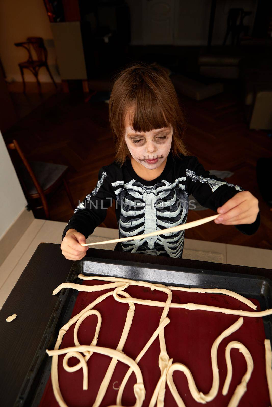 Boy child in skeleton costume preparing for halloween holiday by Demkat