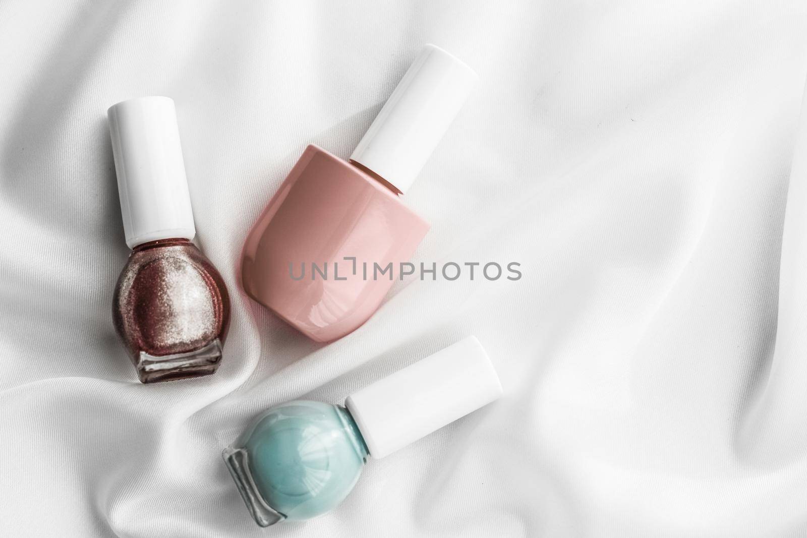 Cosmetic branding, salon and glamour concept - Nail polish bottles on silk background, french manicure products and nailpolish make-up cosmetics for luxury beauty brand and holiday flatlay art design