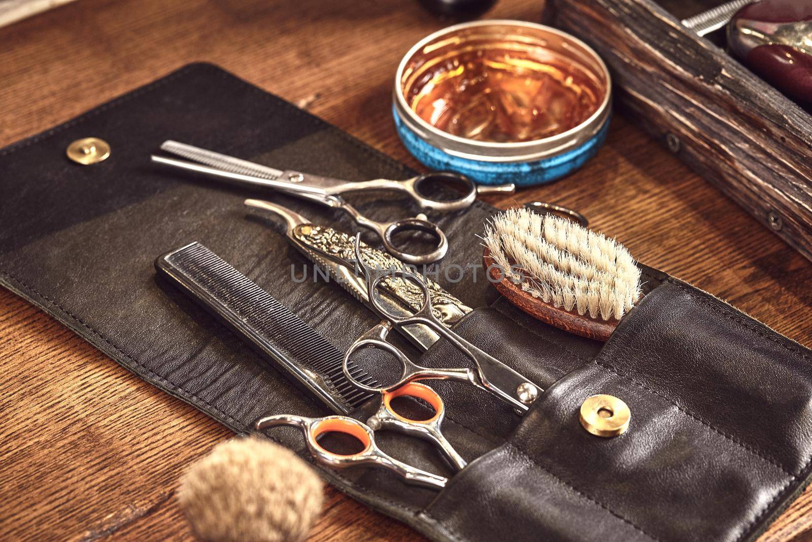 Hairdresser tools on wooden background. Top view on wooden table with scissors, comb, hairbrushes and hairclips, trimmer. by nazarovsergey