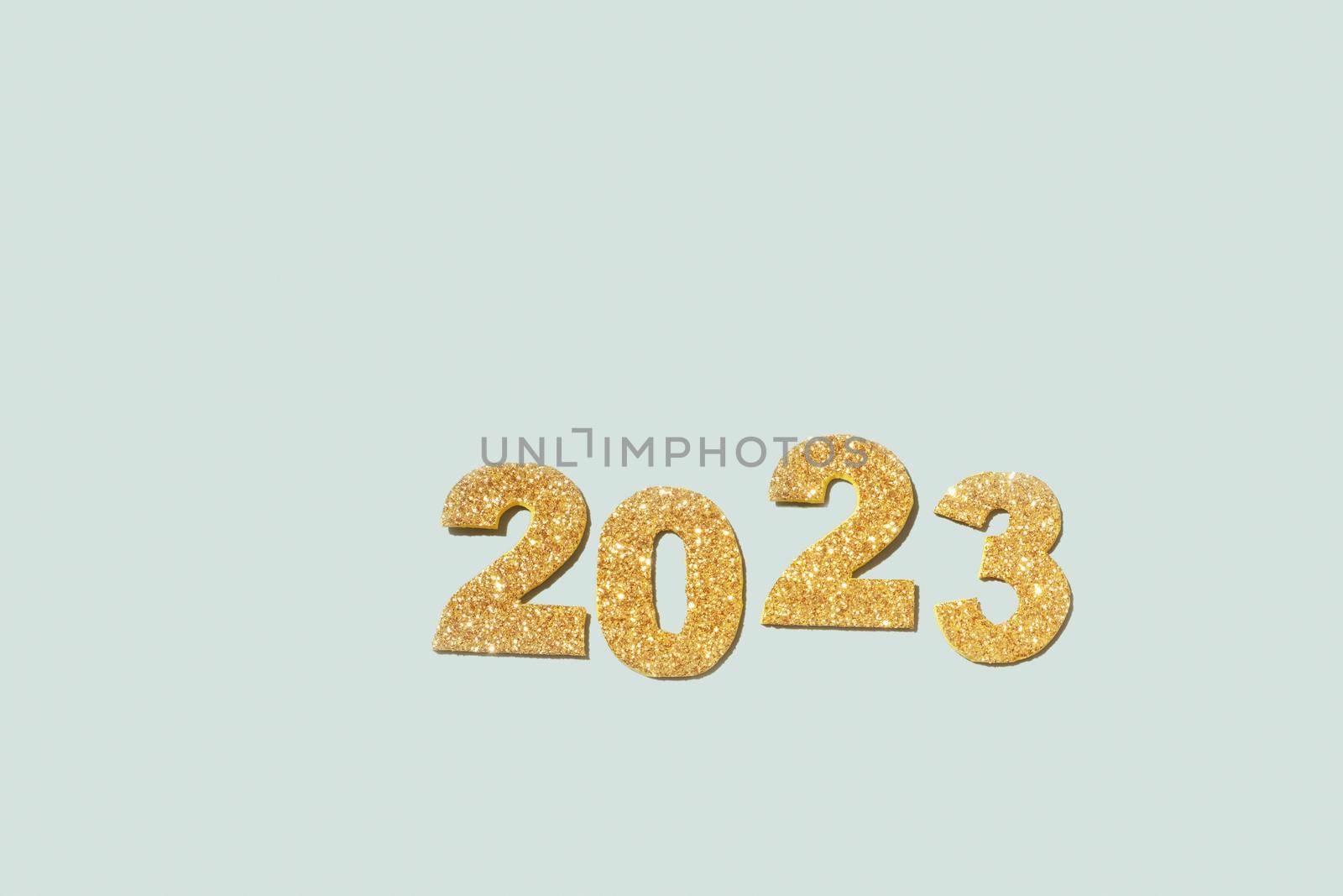 Golden glitter of the numbers 2023 is a symbol of the coming new year. Top view, copy space.