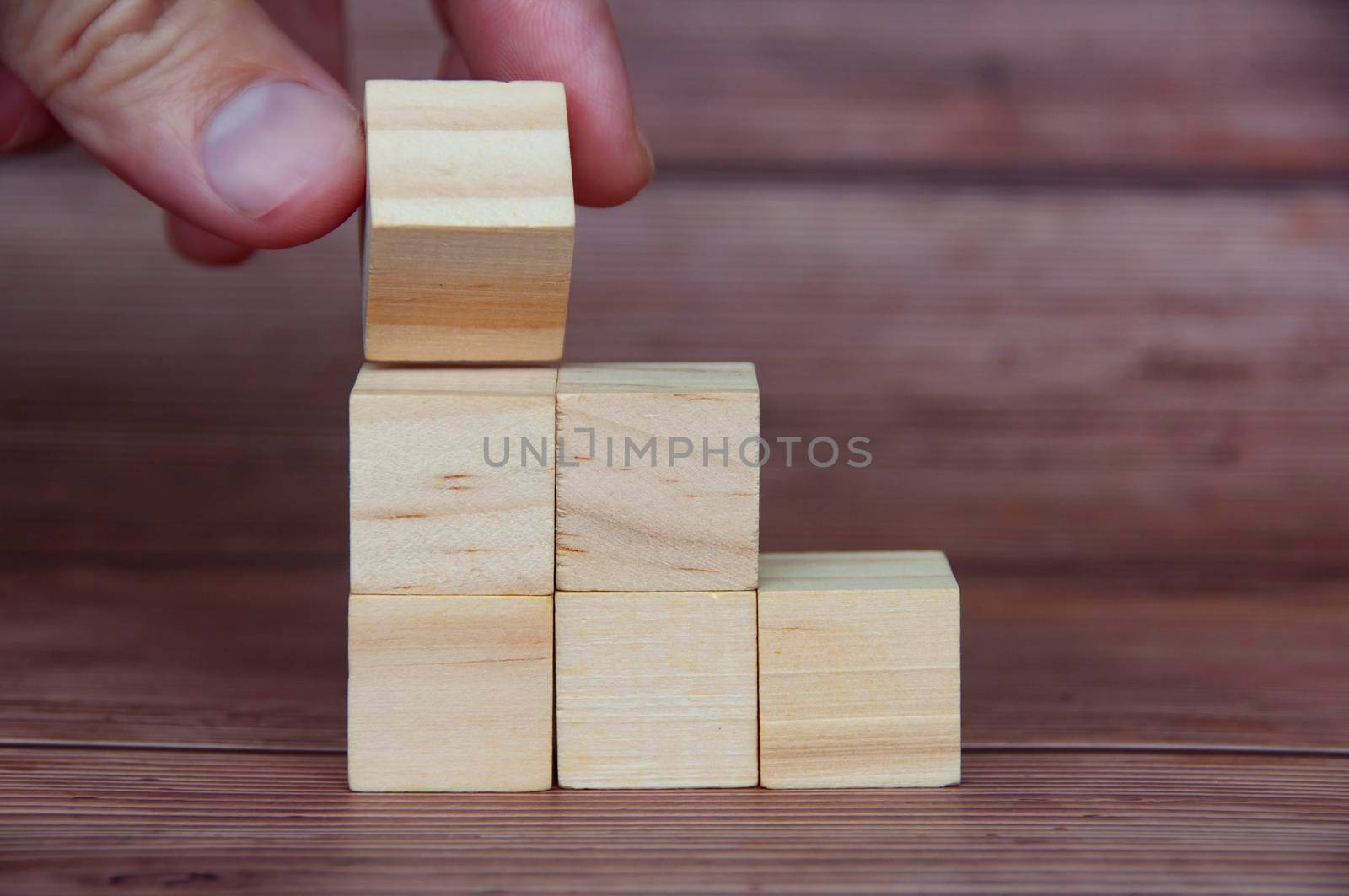 Hand turning a wooden block with customizable space for text or ideas. Copy space.