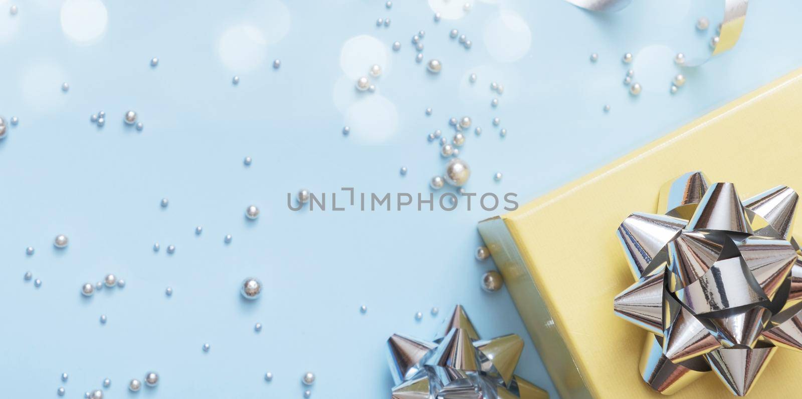 Flat lay Christmas and New Year gift boxes, pearls and bows top view on blue background.