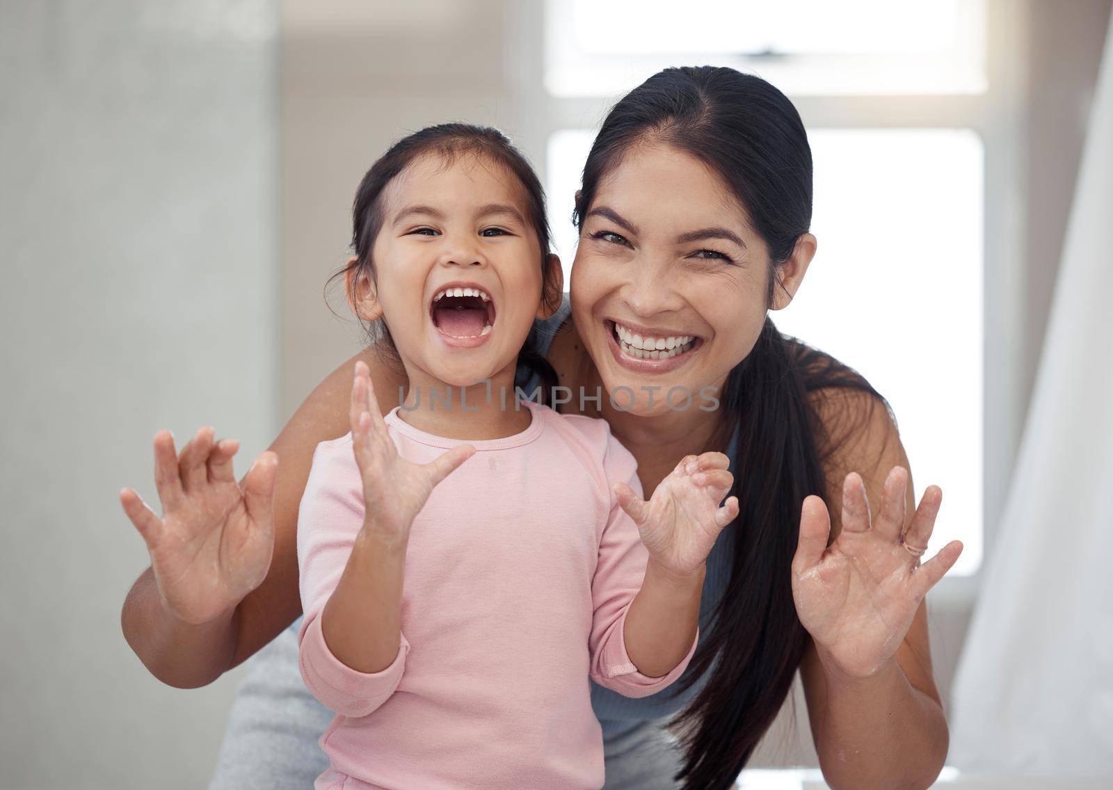 Portrait of mother and child, smile with teeth and morning routine. Asian woman and toddler girl showing clean teeth after brushing it in the bathroom for fun, learning and child development.