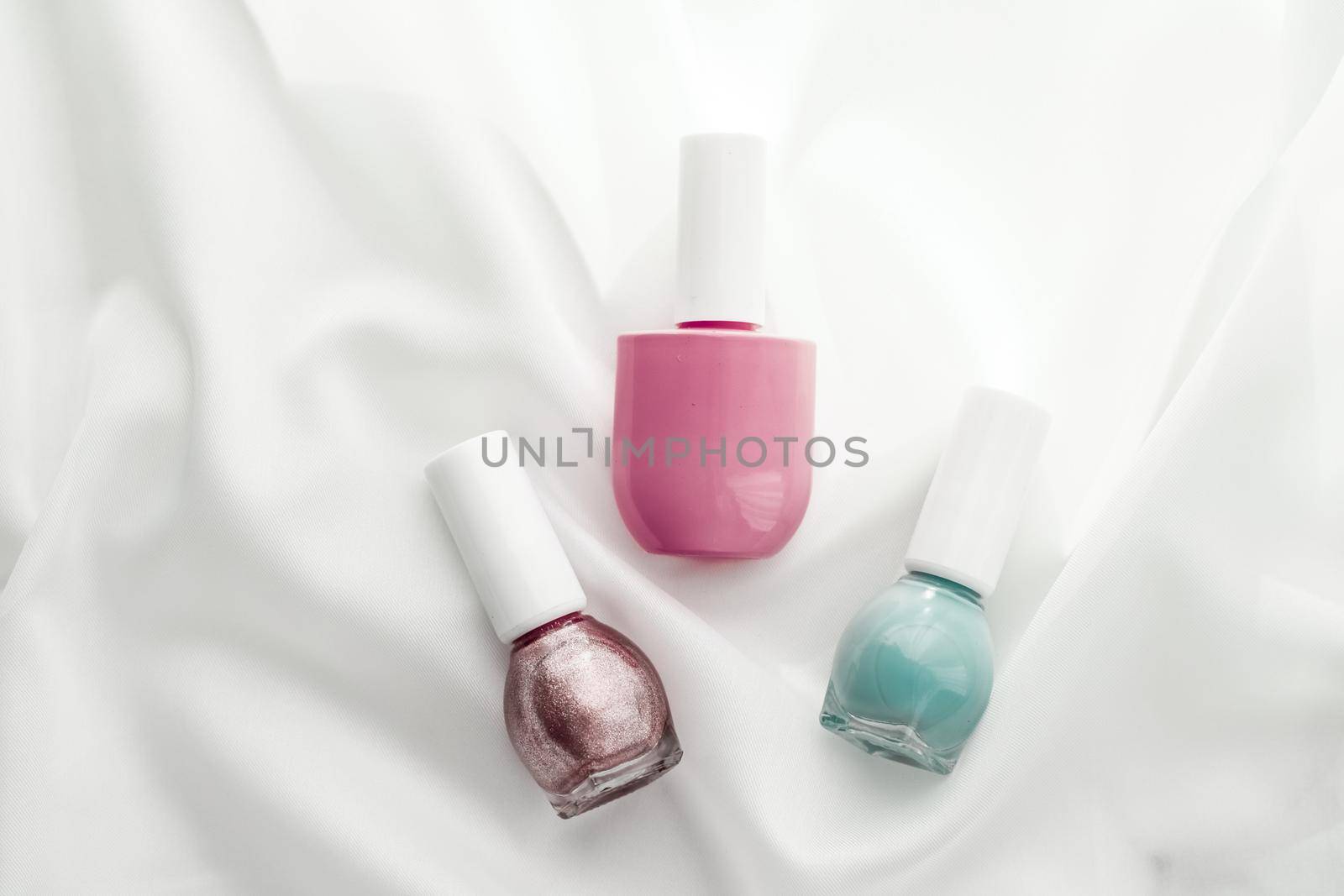 Cosmetic branding, salon and glamour concept - Nail polish bottles on silk background, french manicure products and nailpolish make-up cosmetics for luxury beauty brand and holiday flatlay art design