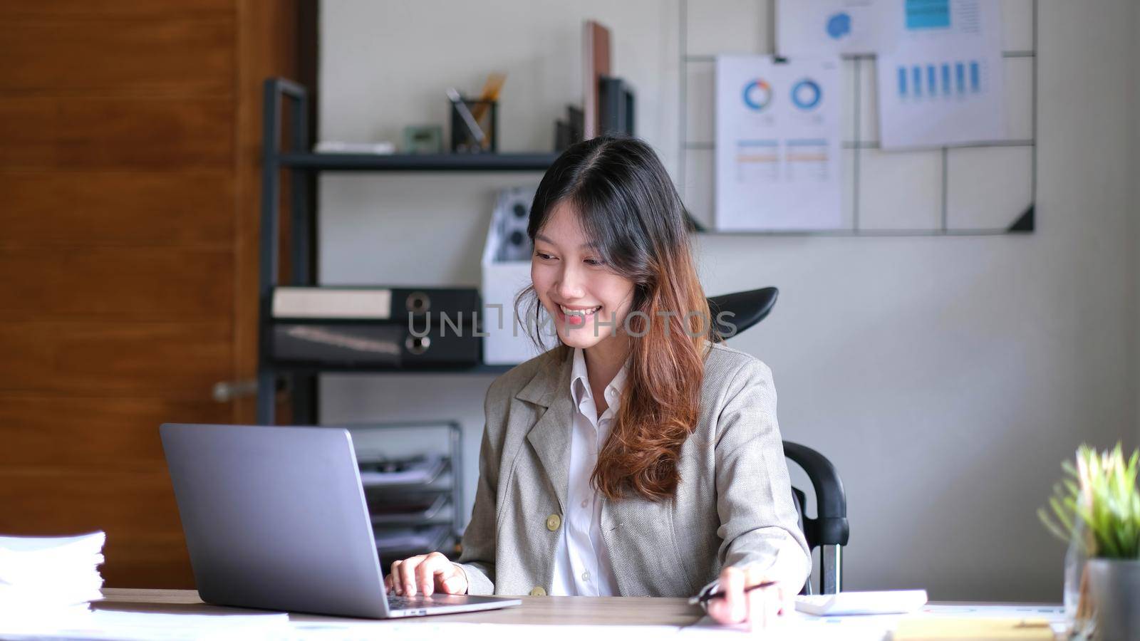 Portrait of smiling beautiful business asian woman working in office use computer with copy space. by wichayada