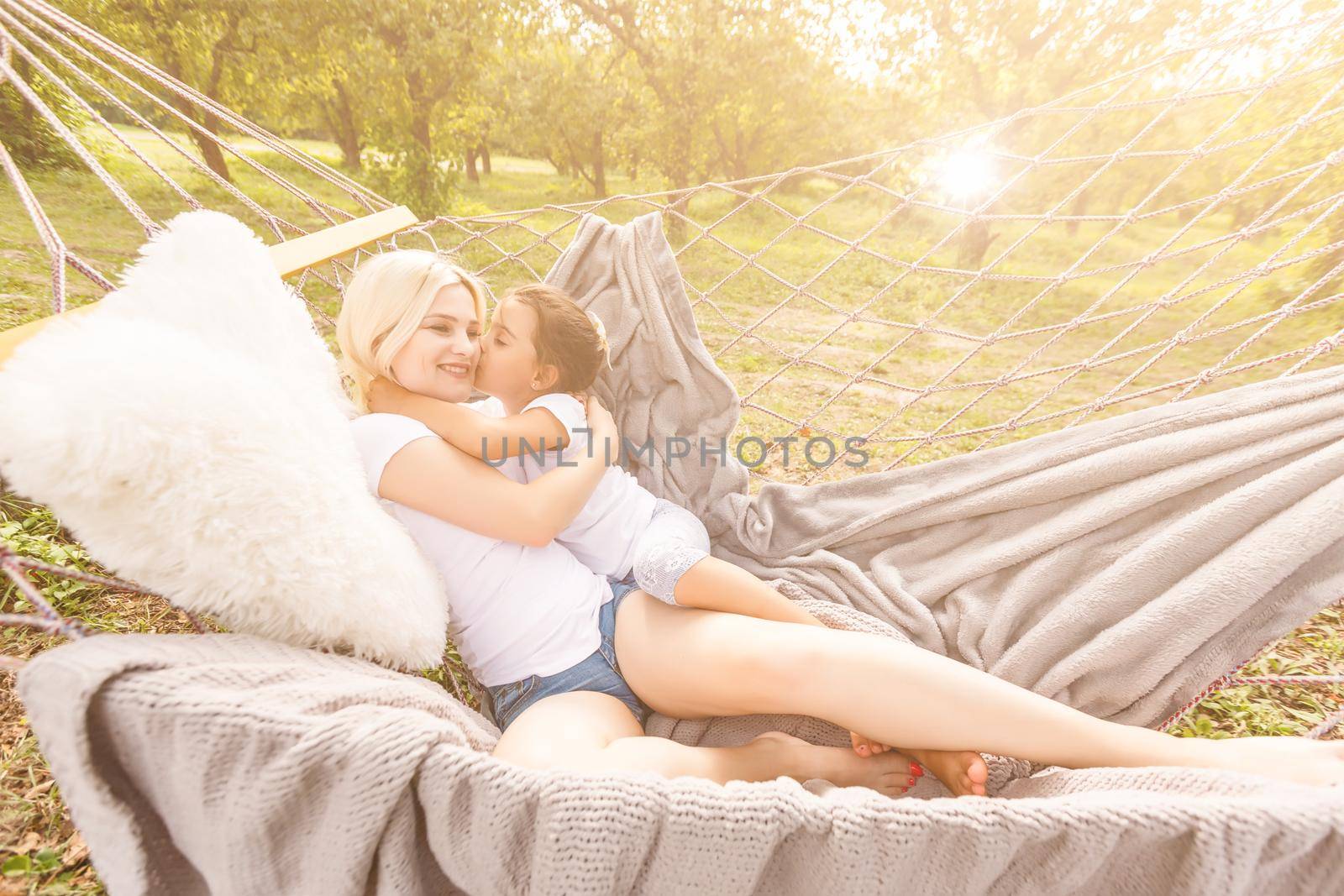 happy mother with her daughter lying in a hammock by Andelov13