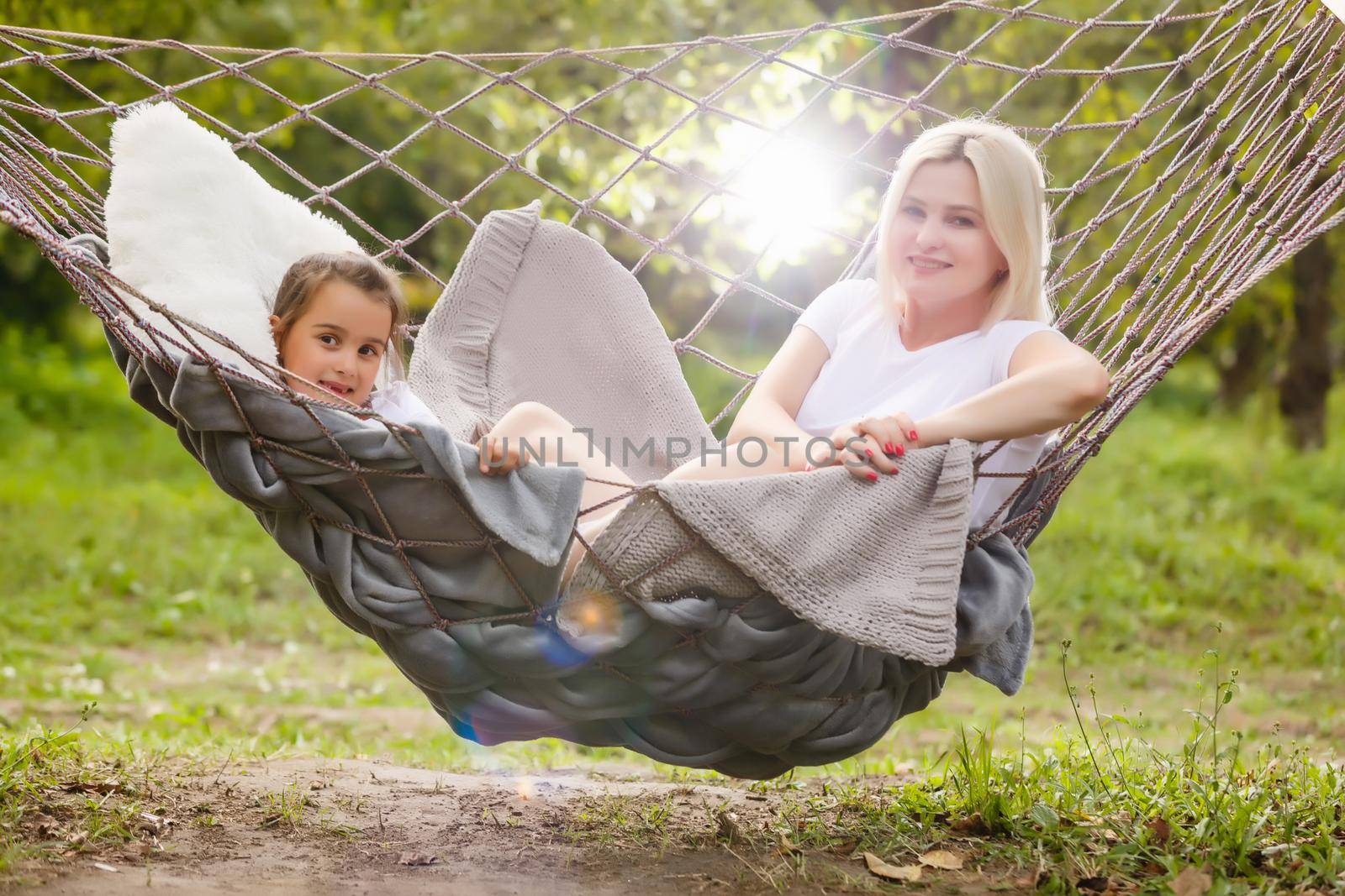 Mother And Daughter Sleeping In Garden Hammock Together by Andelov13