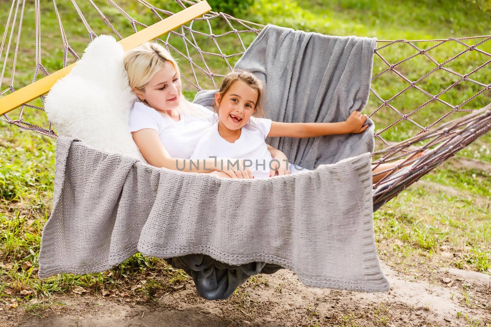 Beautiful young mother with her daughter in forest glade. Happy family relationships. Caucasian woman with baby playing outdoor. Maternal love, caring. Sunshine. Mother's Day by Andelov13