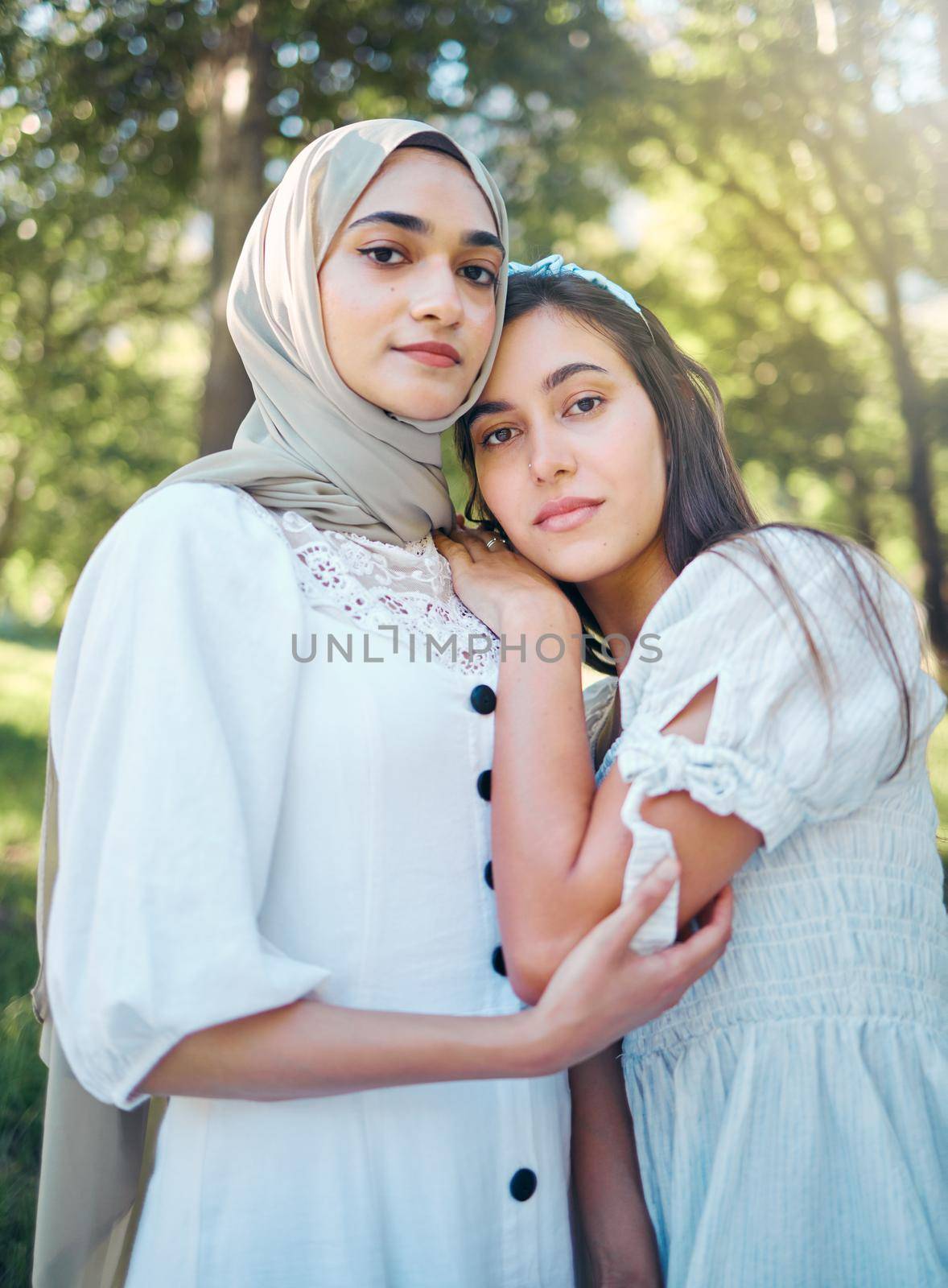 Muslim woman, friends and trust while standing outside in a park and nature with support, love and a good relationship. Portrait middle eastern arab women beautiful in modest Islam fashion with hijab by YuriArcurs