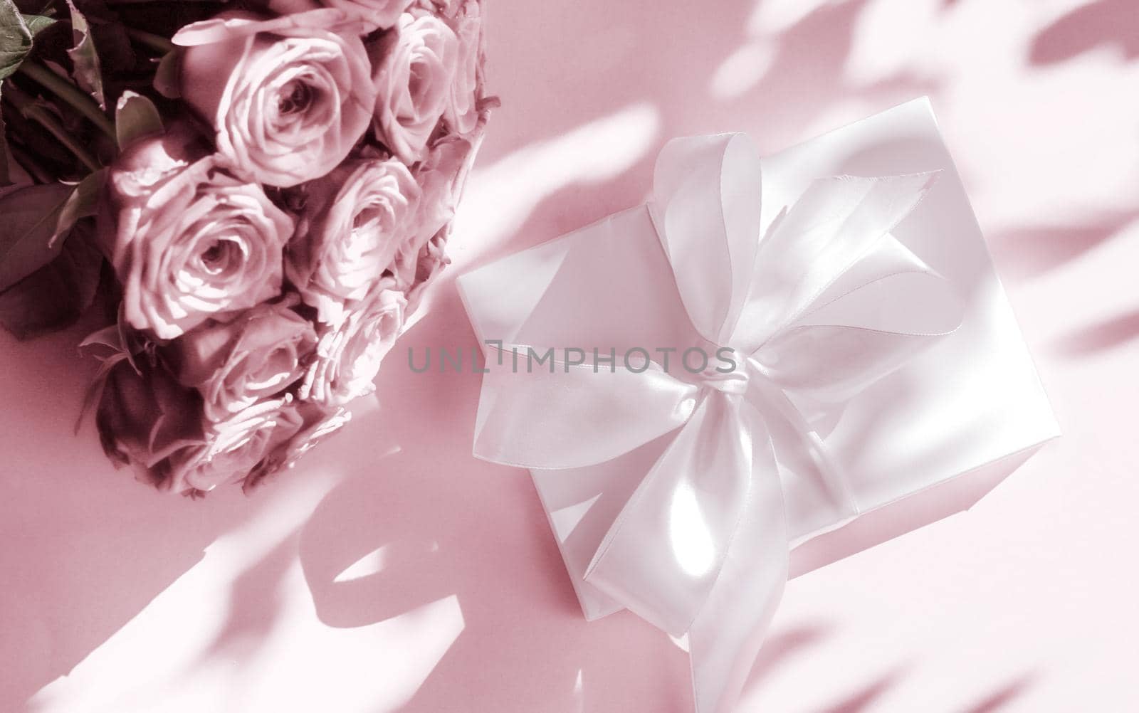 Happy holidays, luxe shopping and love gifts concept - Luxury holiday silk gift box and bouquet of roses on blush pink background, romantic surprise and flowers as birthday or Valentines Day present