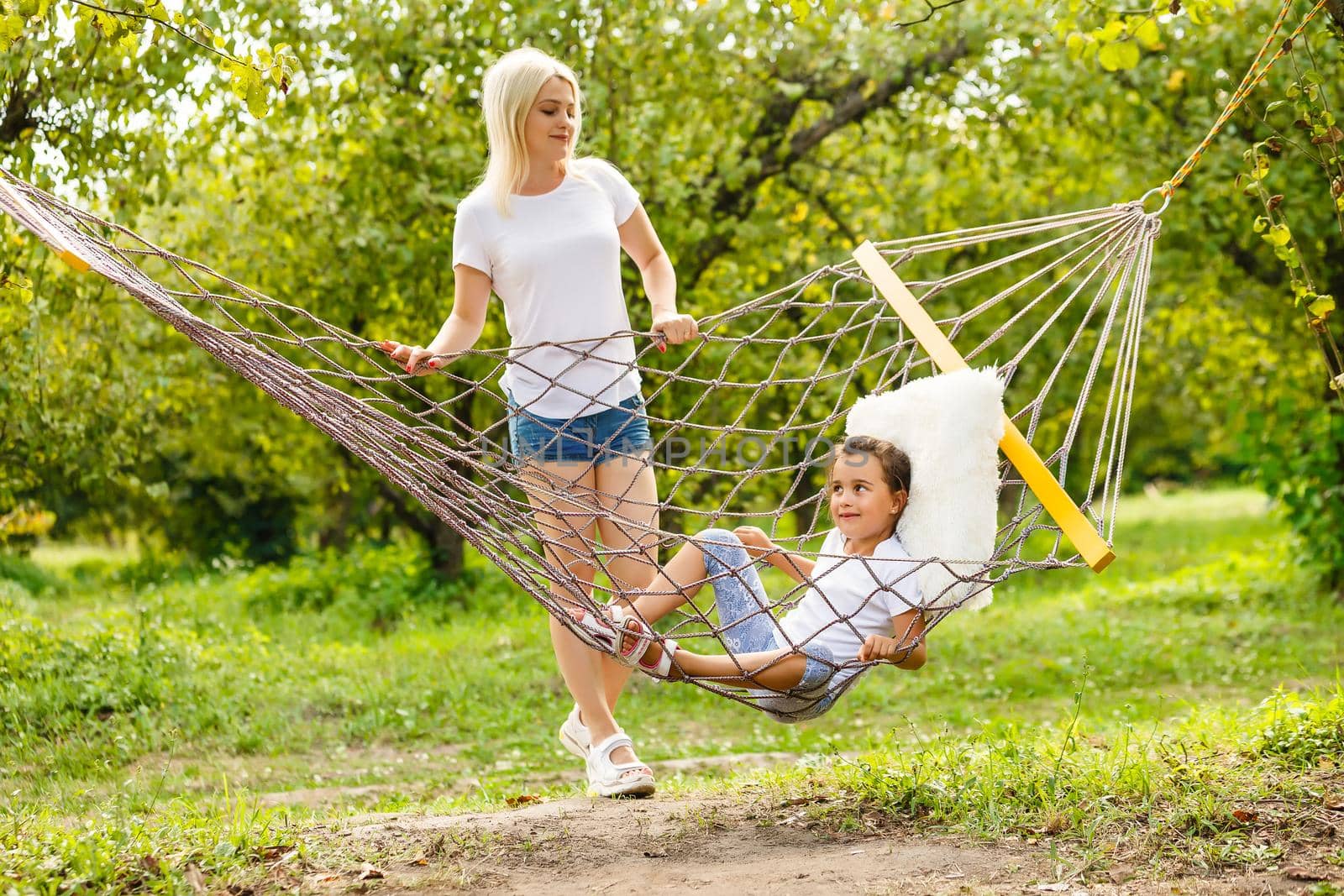 Beautiful young mother with her daughter in forest glade. Happy family relationships. Caucasian woman with baby playing outdoor. Maternal love, caring. Sunshine. Mother's Day by Andelov13