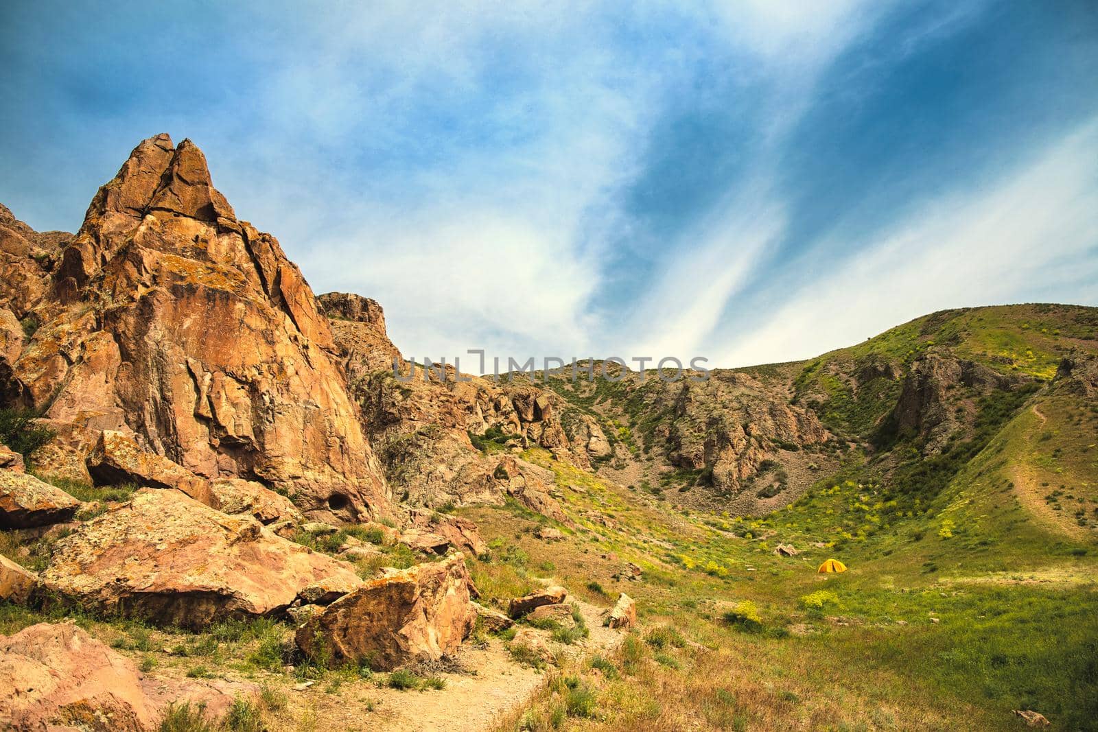 Small yellow tent camouflaged in the highlands, copy space landscape.