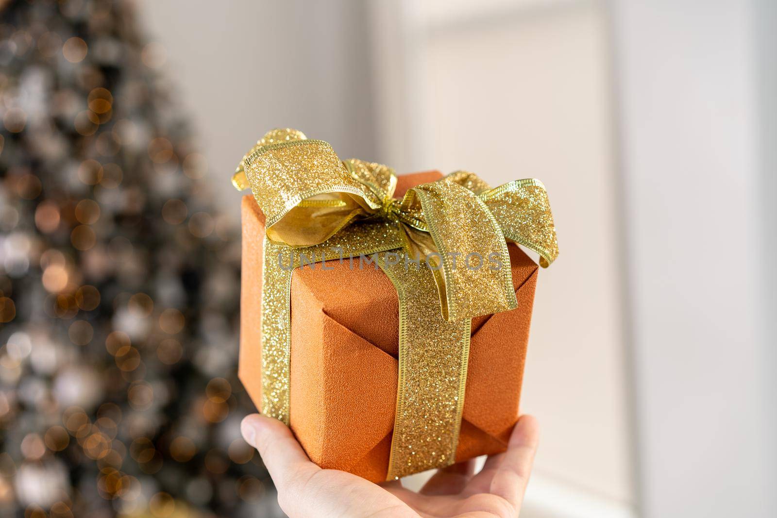 Christmas present gift box stacked close up. Holiday sale concept. Many gift box black, white, orange color with gold ribbon and light garland