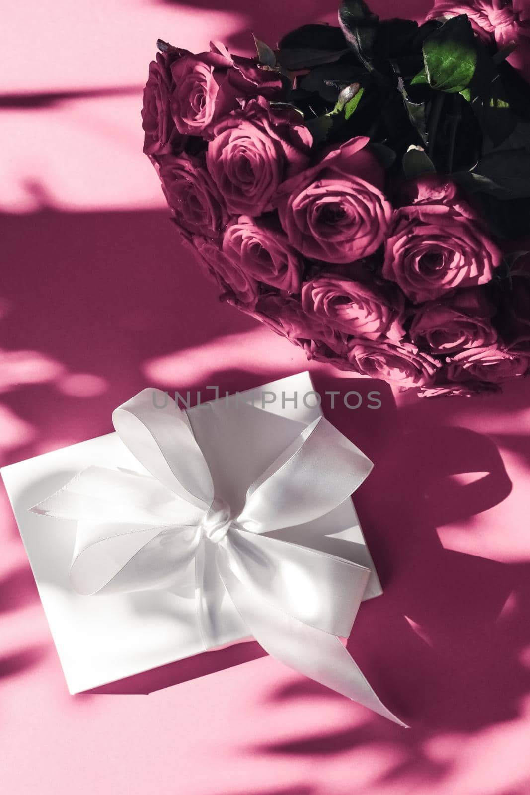 Happy holidays, luxe shopping and love gifts concept - Luxury holiday silk gift box and bouquet of roses on pink background, romantic surprise and flowers as birthday or Valentines Day present