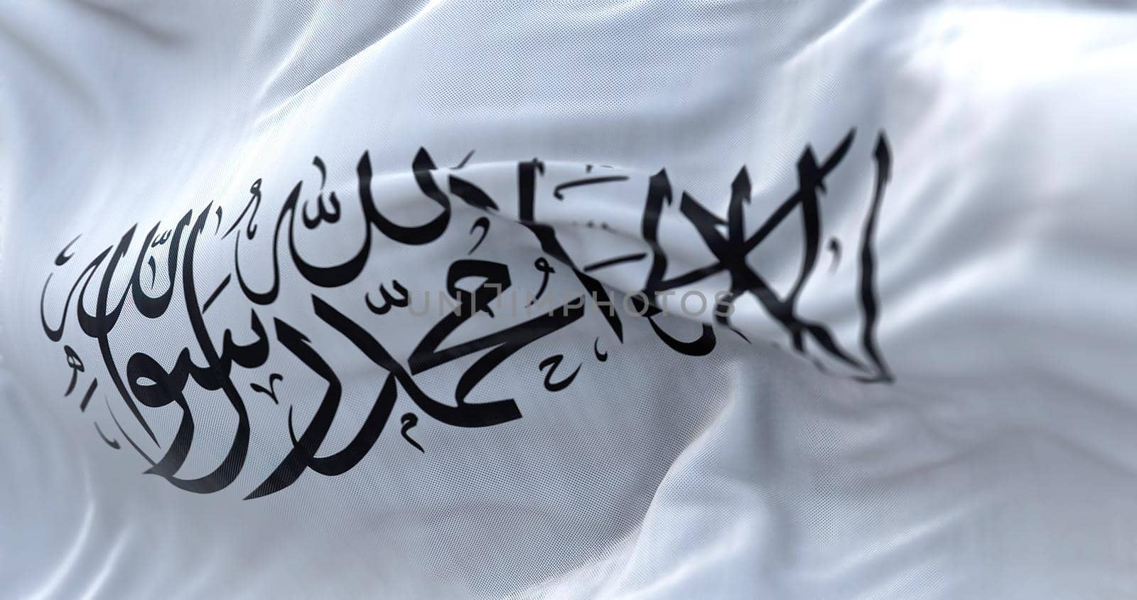 The flag of the Islamic Emirate of Afghanistan waving in the wind. It is an unrecognized Islamic emirate that was established by taliban in August 2021 with the fall of Kabul