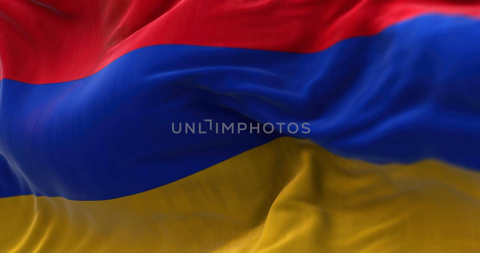 Close-up view of the armenian national flag waving in the wind. Armenia is a landlocked country located in the Armenian Highlands of Western Asia. Fabric textured background. Selective focus