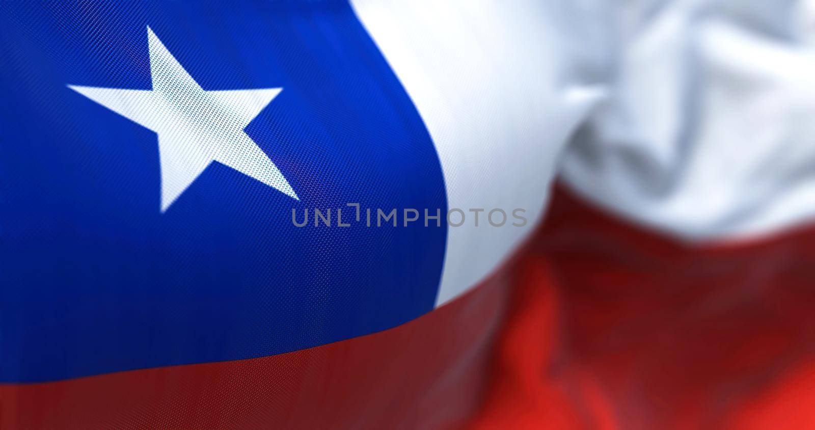 Close-up view of the Chile national flag waving in the wind. The Republic of Chile is a country in the western part of South America. Fabric textured background. Selective focus