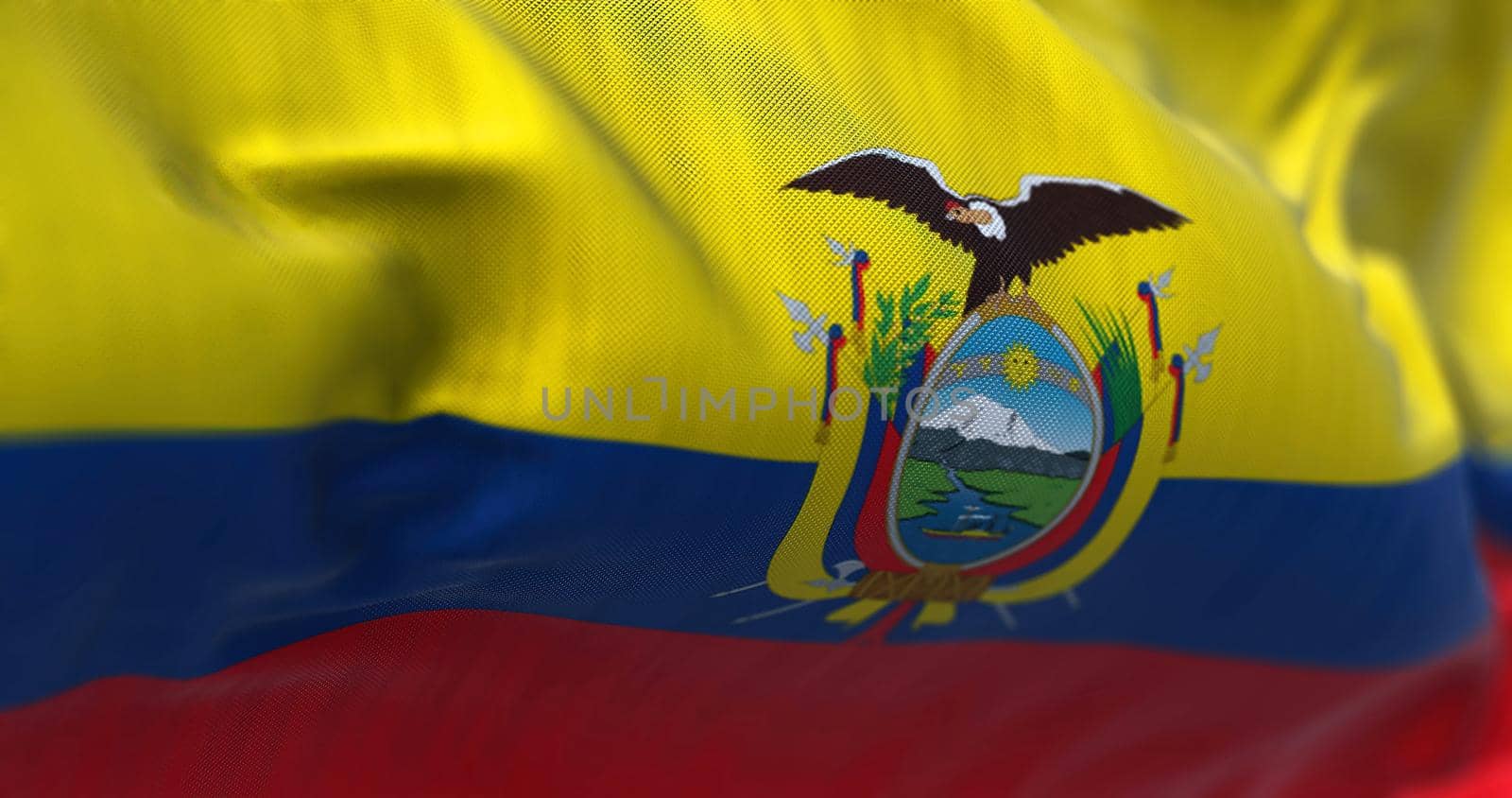 Close-up view of the Ecuador national flag waving in the wind. The Republic of Ecuador is a country in northwestern South America. Fabric textured background. Selective focus