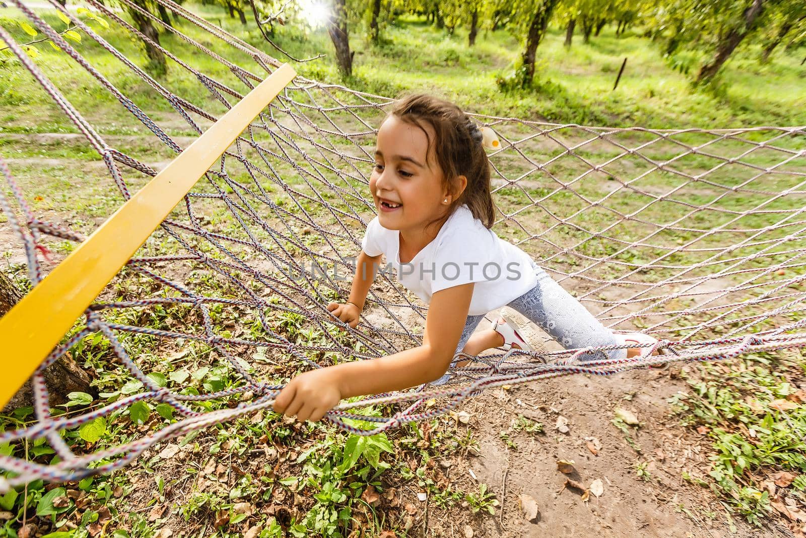 Little girl relaxing in hammock outdoors. Summer camp, vacation concept