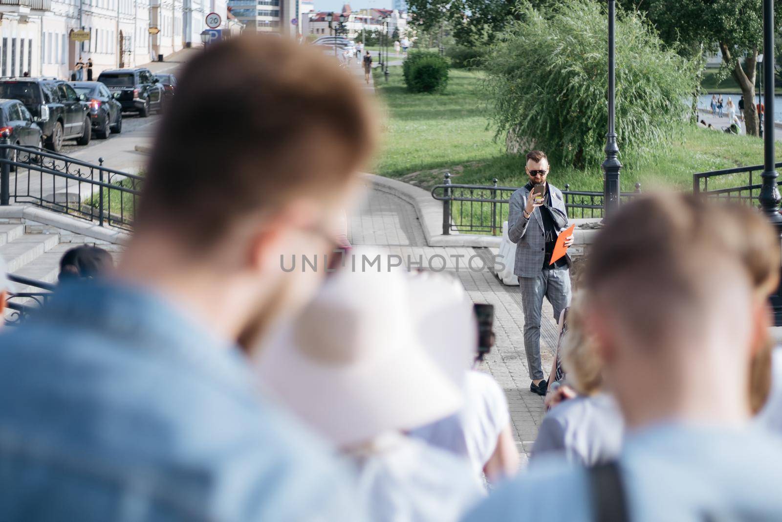 young man is a tour guide telling a group of tourists about local attractions.