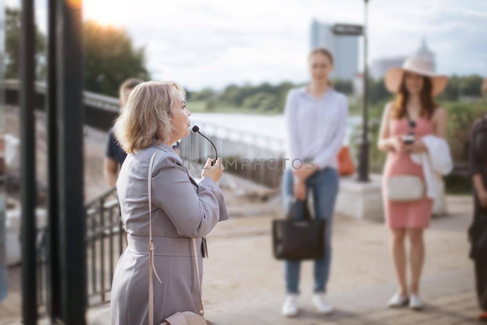 female guide communicates with a group of tourists. by SmartPhotoLab