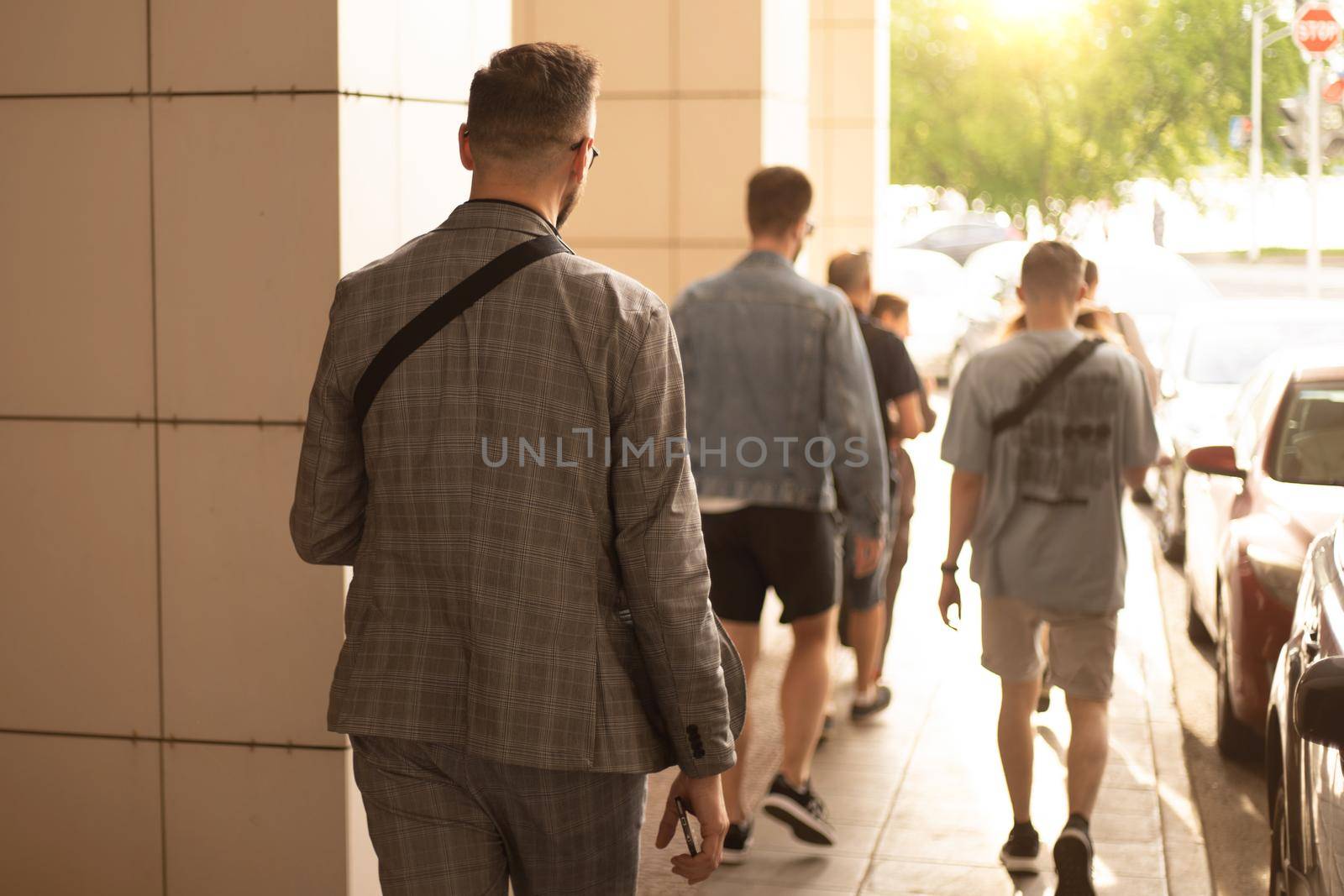 group of tourists walking along a city street. by SmartPhotoLab