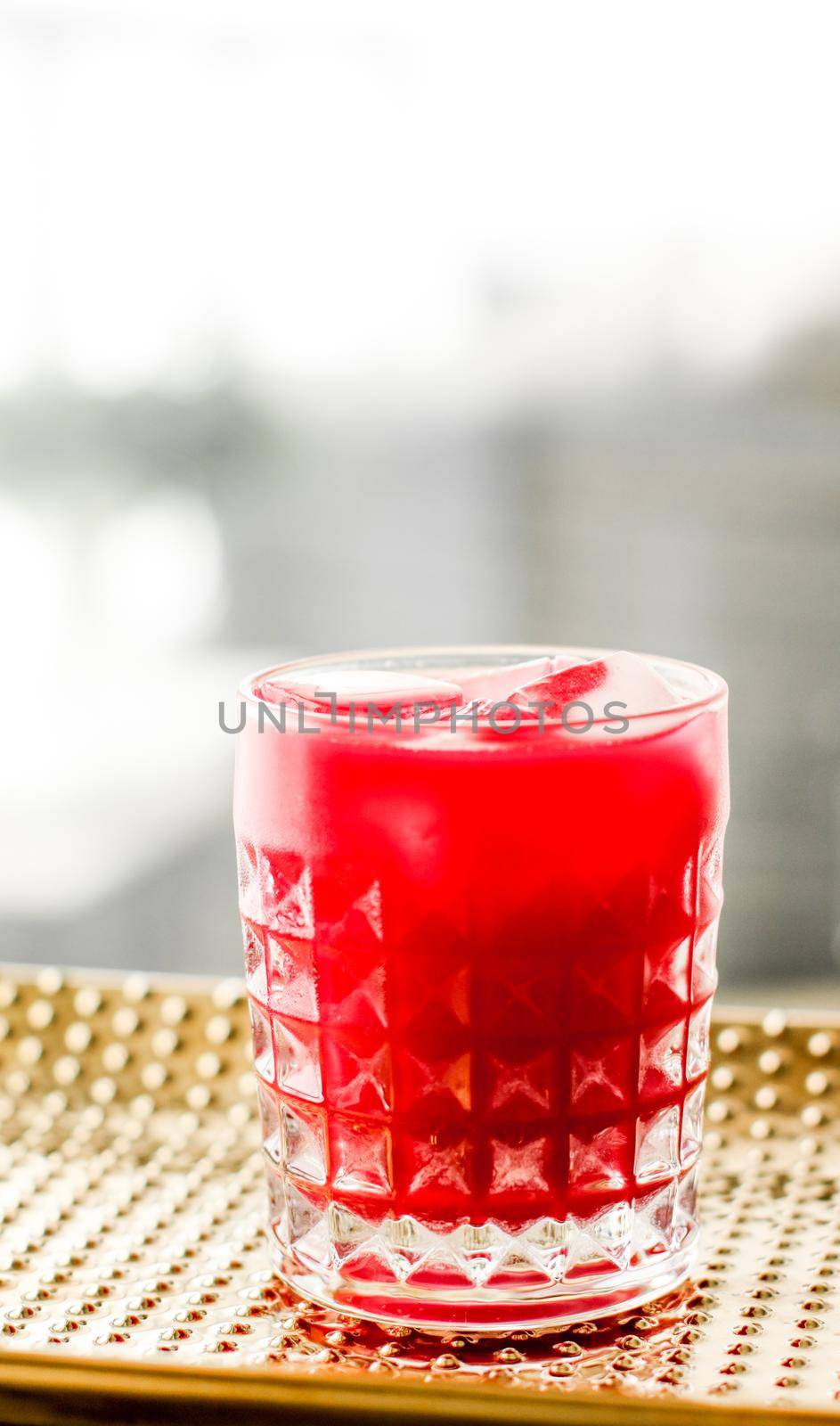 Alcohol drink, refreshment and cold beverage concept - Glass of red cocktail with ice, luxury bar party
