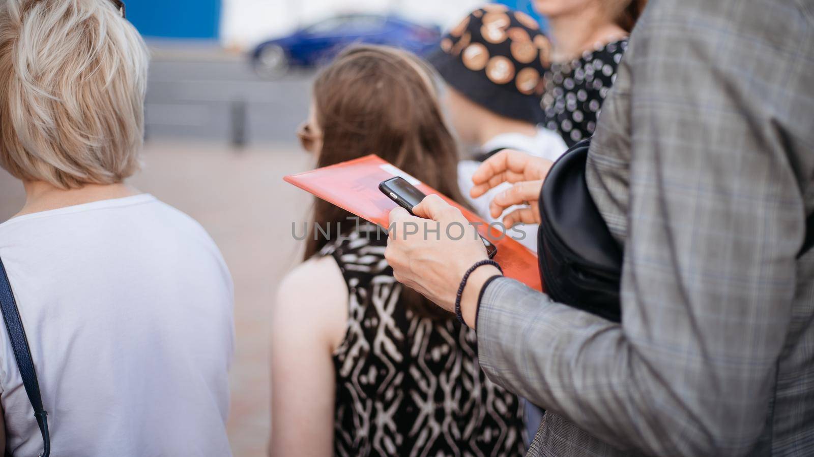 image of a group of tourists listening to their guide . by SmartPhotoLab