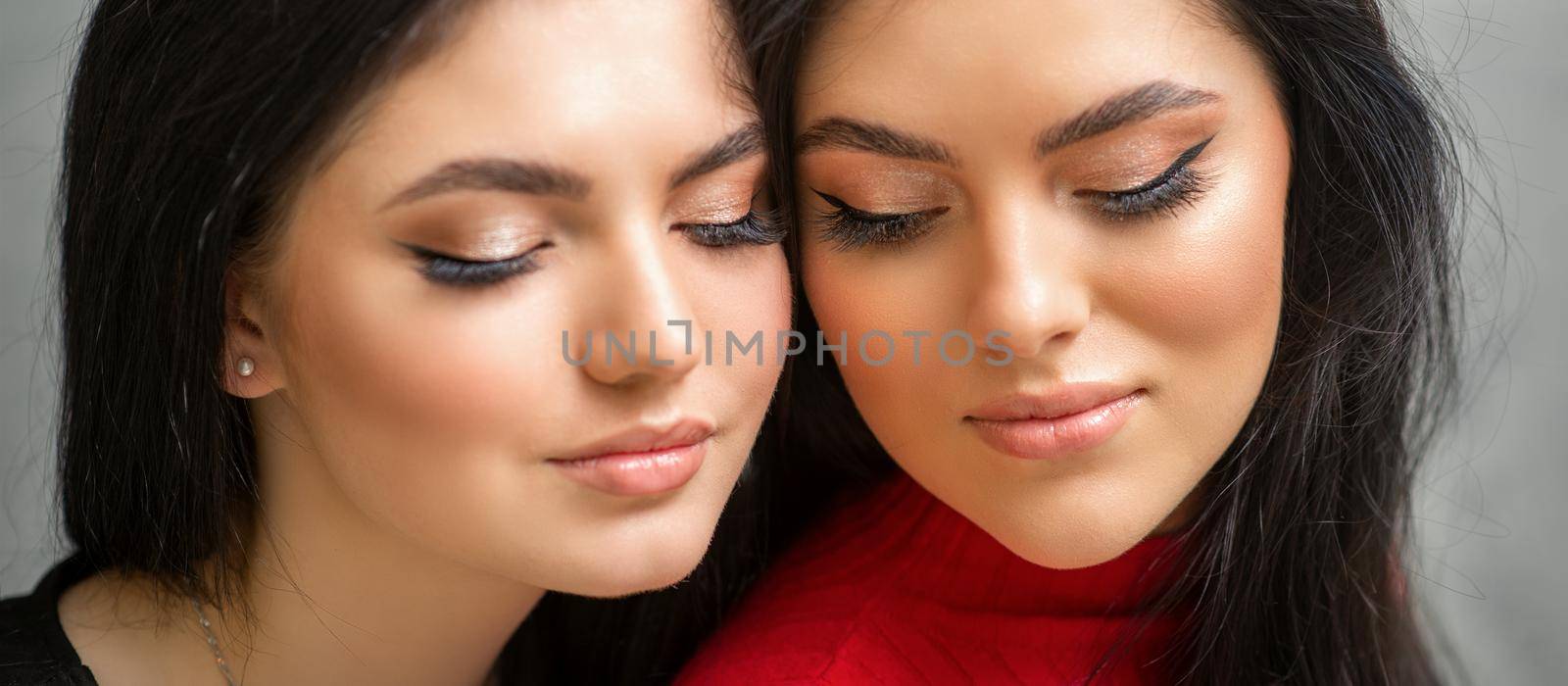 Portrait of young beautiful two women with long lashes and closed eyes after eyelash extensions