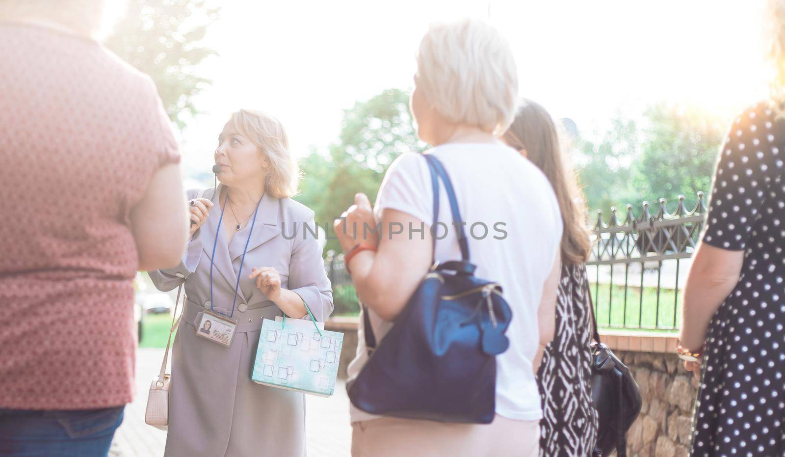 female guide is telling a group of tourists about something. close-up.