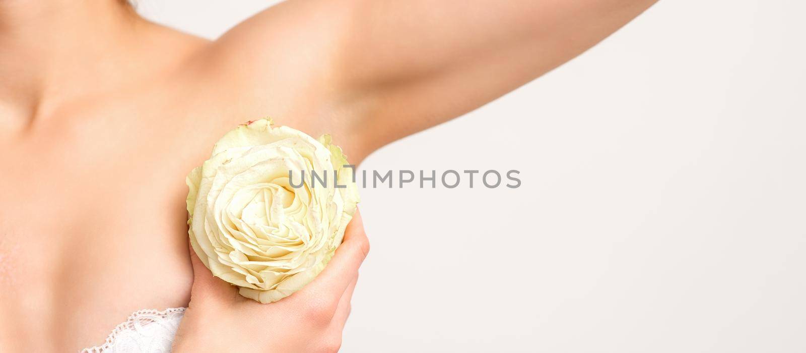 Close up of female armpit with white rose flower isolated on white background