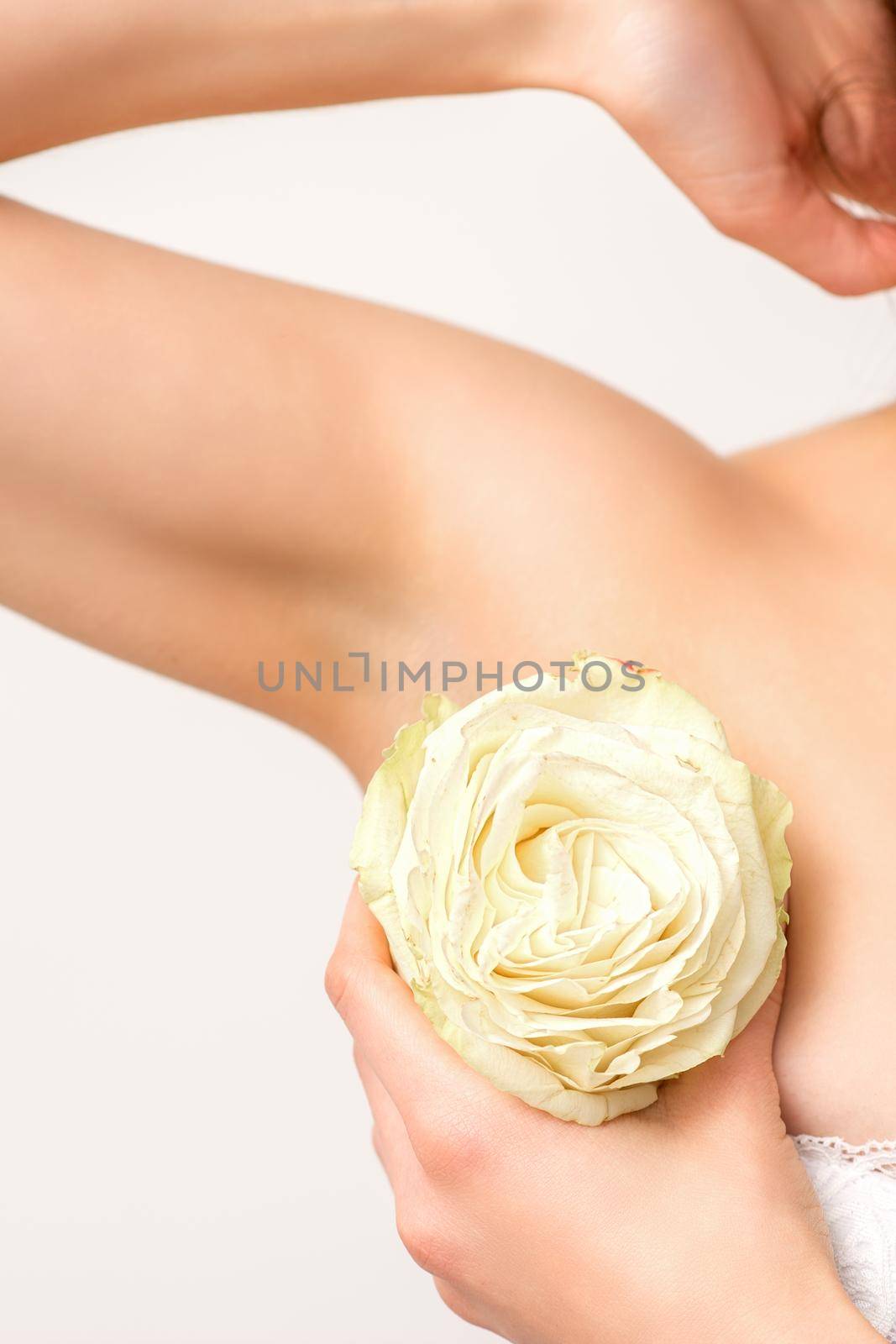 Close up of female armpit with white rose flower isolated on white background
