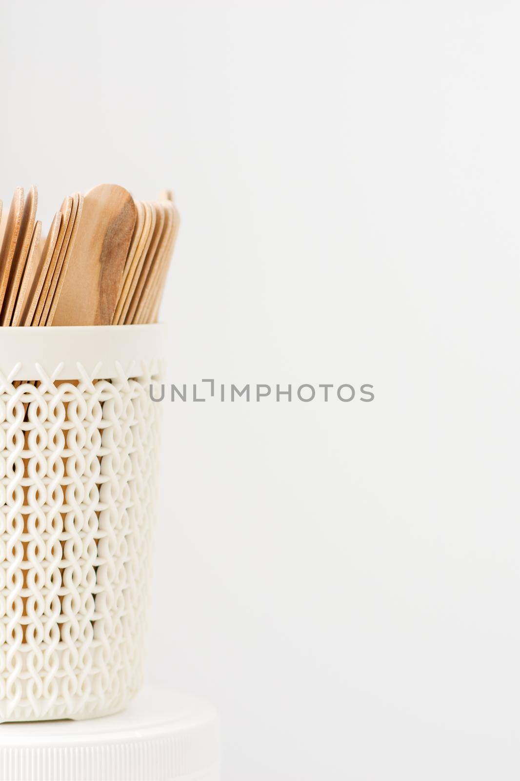 Sticks of wood for wax in white basket isolated on white background with copy space