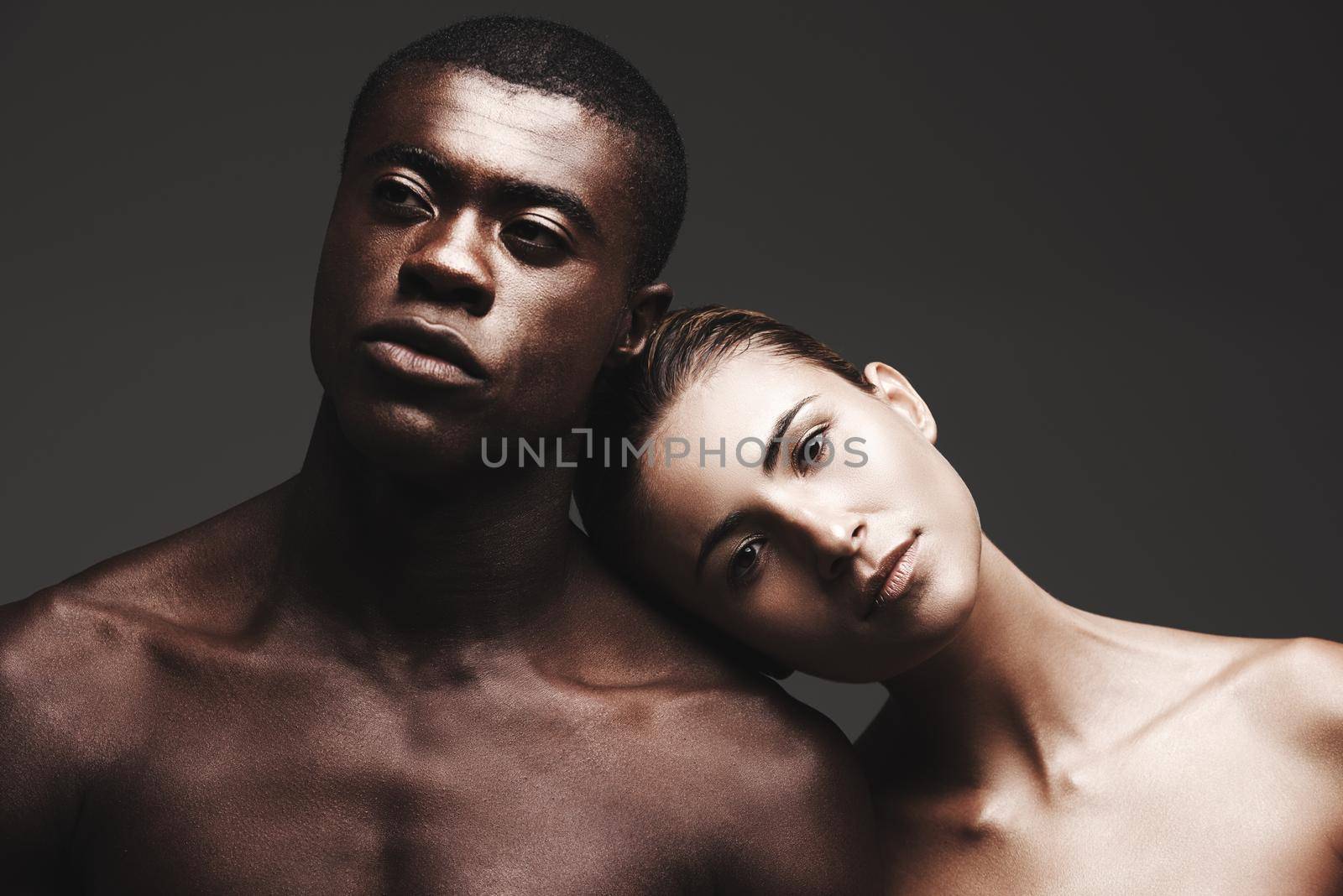 They see the beauty in each other. a beautiful couple posing in a studio - gray background