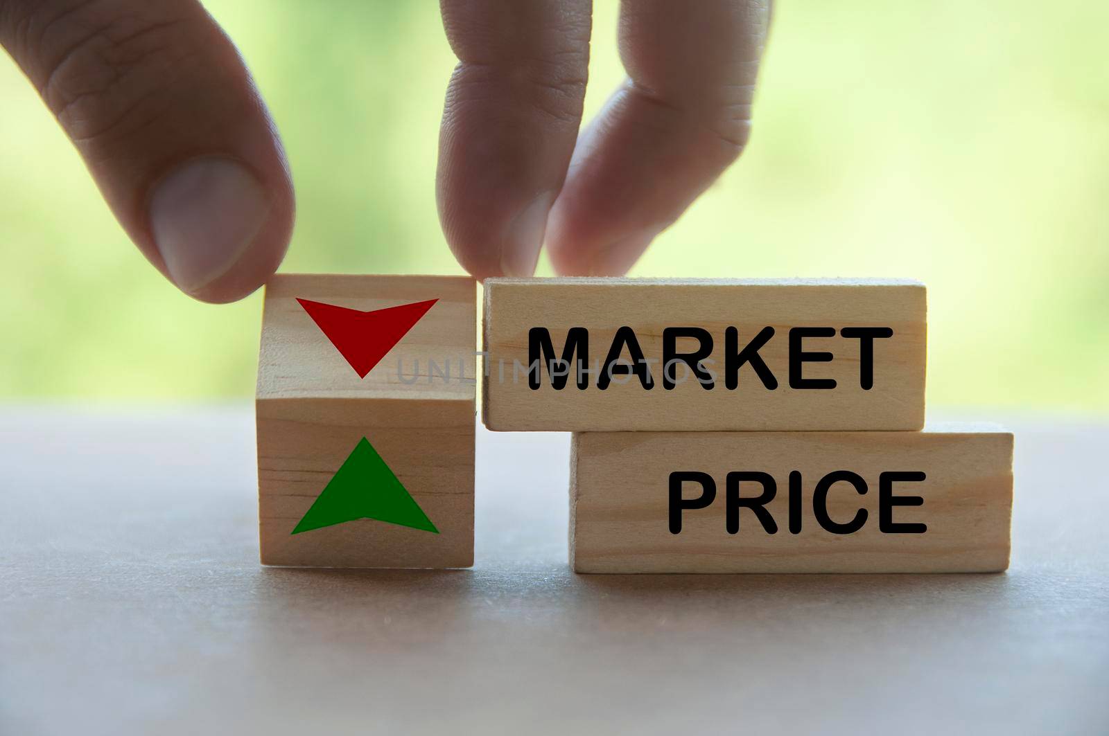 Hand turning direction of arrow on wooden block up and down on market price. Business and market price concept.