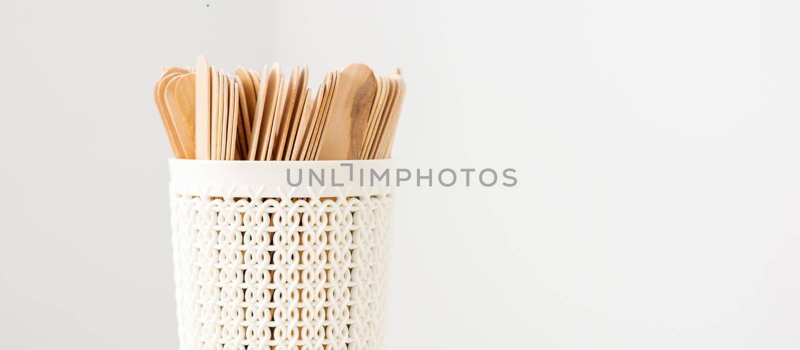 Sticks of wood for wax in white basket isolated on white background with copy space