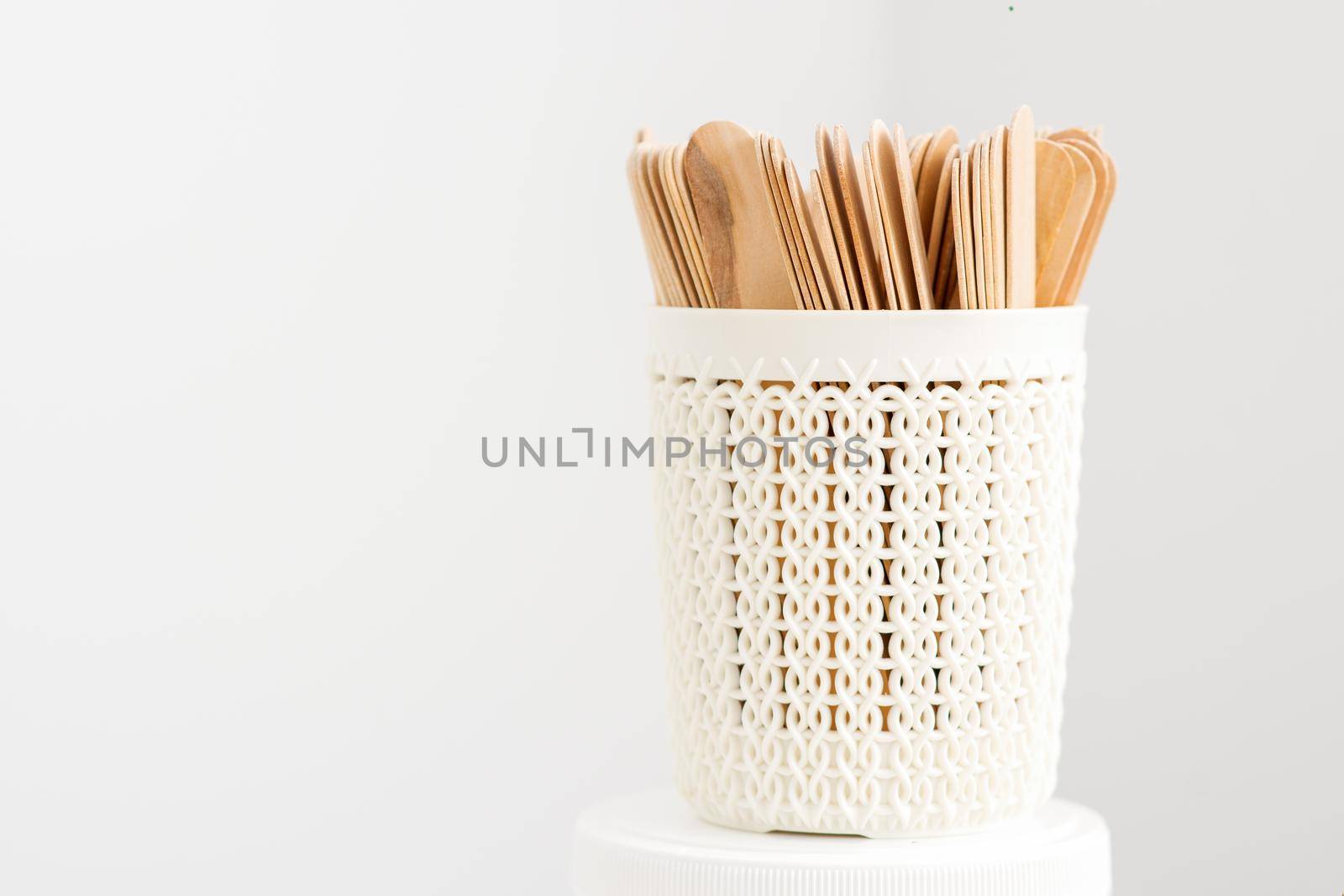 Sticks of wood for wax in white basket isolated on white background with copy space