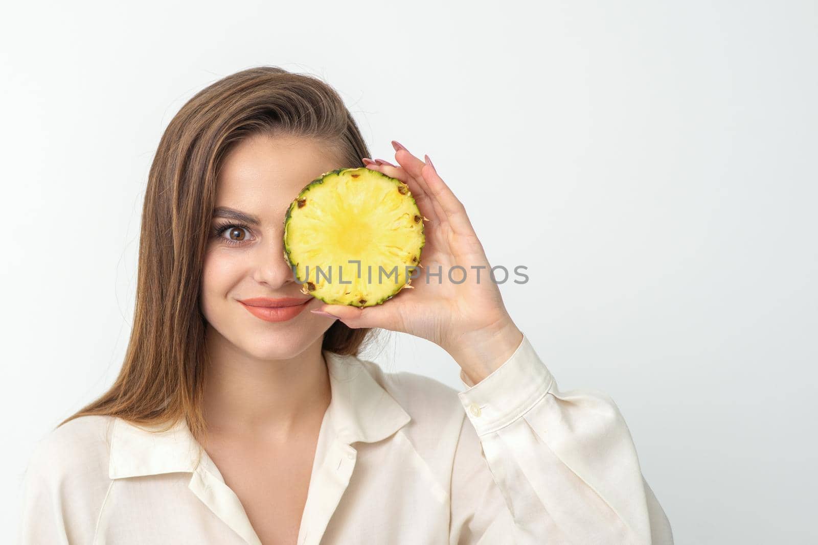 Attractive pretty nice young caucasian woman hold sliced pineapple covering her eye isolated on white color background