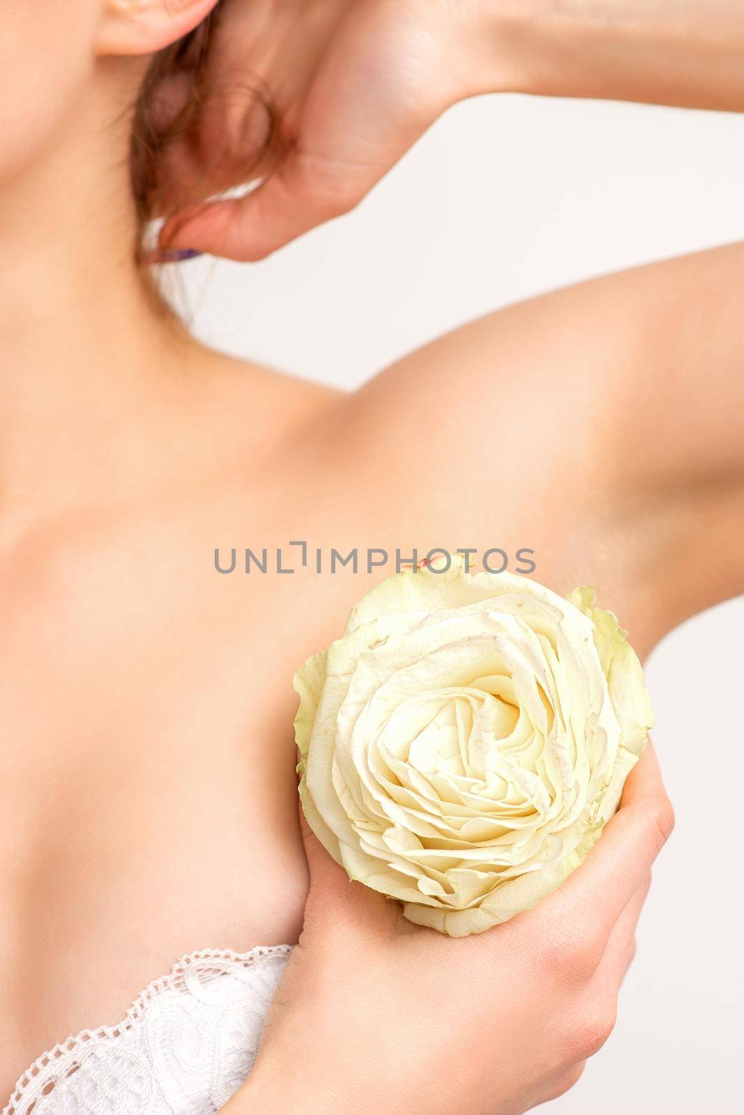 Close up of female armpit with white rose flower isolated on white background. by okskukuruza